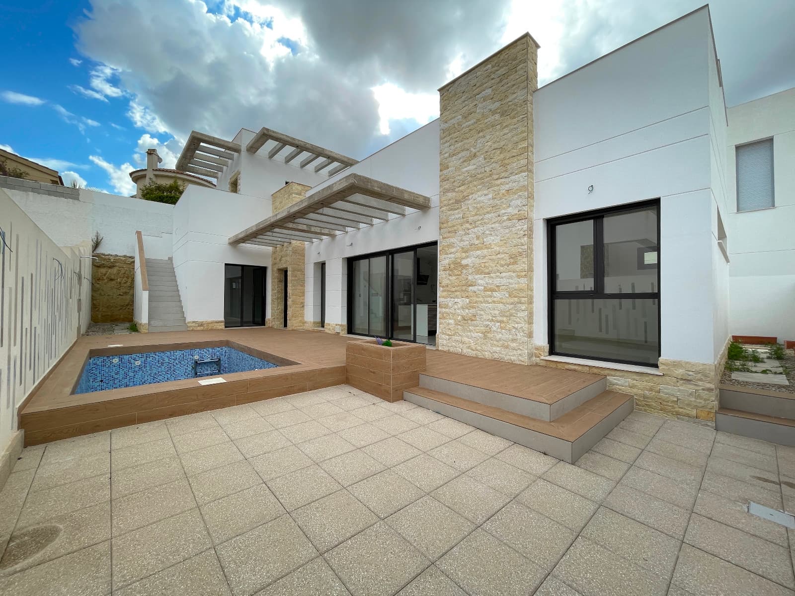 This beautiful detached 3-bedroom, 3-bathroom home is located in Benijófar, steps away from all essential services and the new Benisol shopping center. The spacious interior includes a large living room and an open-plan, fully-equipped kitchen with an oven, microwave, dishwasher, range hood, and refrigerator.The property offers per-installation for air conditioning and built-in wardrobes in every bedroom. On the ground floor, you'll find two of the three bedrooms, including one with an en-suite bathroom, as well as an additional shared bathroom. The third bedroom, also en-suite, is located on the first floor and is accessible by an external staircase, providing an independent entrance. This upstairs suite features a dual-sink bathroom and opens onto a vast 70 m² solarium with stunning mountain views.Outside, enjoy the private swimming pool, parking on the property, and a storage area cleverly designed under the stairs. This home is set in one of Benijófar's most popular areas, blending convenience, privacy, and style.