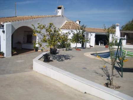 Fed up of the gloomy UK weather? Do you want to soak up the sun with a sea breeze and a cocktail? Do you want to make life long memories in your own holiday home? Do you want to relocate to the sun? Then look no further this property could be just what your looking for – This stunning detached villa is in the lovely area of Sucina. It contains 4 spacious bedrooms, 2 family bathrooms and one en-suite in the master bedroom. This property is huge as it has consists of 2 separate lounges, 2 kitchens and a dining area. This villa has a huge plot of 1200sqm plus a build size of 282sqm which has been maintained very well. On this amazing plot there are some lovely orange and lemon trees, a tiled undercover porch perfect for relaxing and also your very own private pool to cool off in the hot summer days. If you love entertaining guests then this property is perfect for you as it not only has an outdoor kitchen but also a BBQ to enjoy all throughout the year. The airport of San Javier is approx a 10 minute drive and the airport of Alicante is approx a 60 minute drive. There are local beaches approx a 10 minute drive from this property and local amenities are within an easy reach. Should you require any further information on this or any other property please do not hesitate to contact a friendly member of our team.