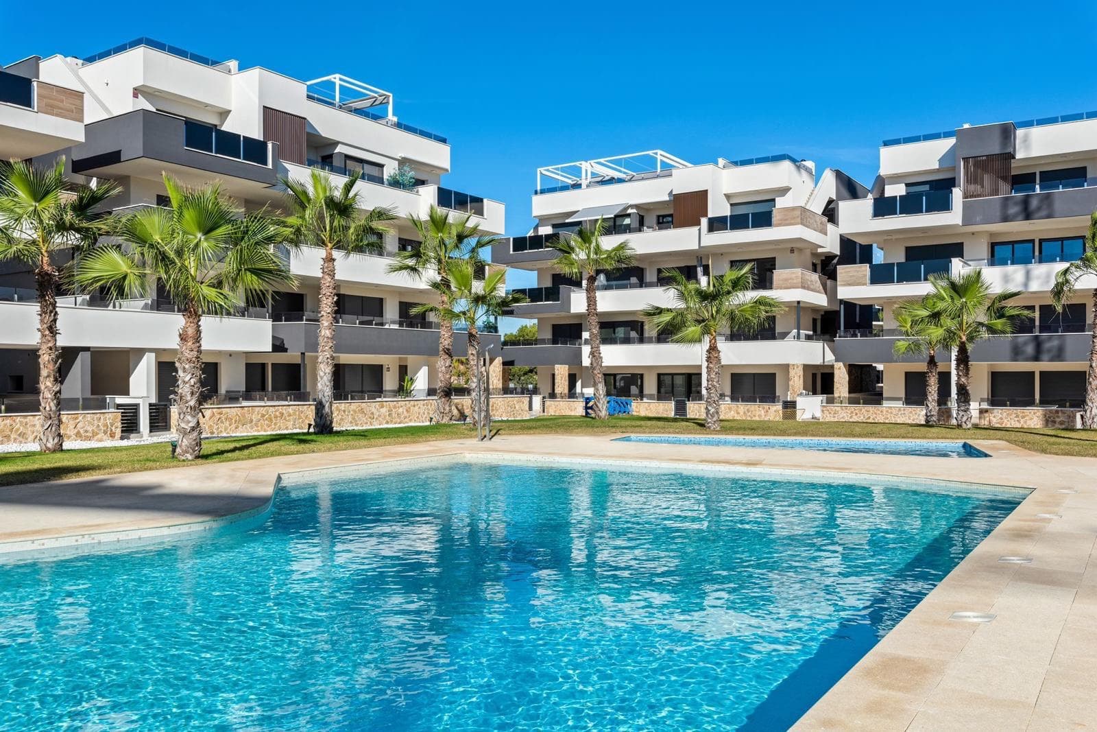 This beautiful ground-floor apartment is located in Amanecer IX. The apartment has 2 bedrooms, 2 bathrooms, and an open kitchen. It is a central apartment, which means it has a larger terrace area and access to the terrace from every bedroom and the living room. The terrace is a spacious 48 m², offering views of the garden and swimming pool.

The apartment is sold fully furnished, including all furniture, white goods, kitchenware, towels, garden furniture, and more. Everything stays. The apartment has been rented out as a holiday home, so it’s equipped with everything you need for daily living.

An underground parking space and a storage room are also included in the price.

This gem is located in Los Altos, one of the most sought-after areas of Orihuela Costa. It offers a range of amenities nearby. Just a short walk away, you'll find a supermarket and other stores for all your daily needs, and the La Zenia Boulevard shopping center is also close by. The beautiful beaches of Orihuela Costa are just a short drive away, perfect for a day in the sun and by the sea. Additionally, there are numerous dining and drinking options in the area, where you can enjoy a variety of restaurants and cafés. For golf enthusiasts, there are also several golf courses nearby.

Contact us to schedule a viewing!