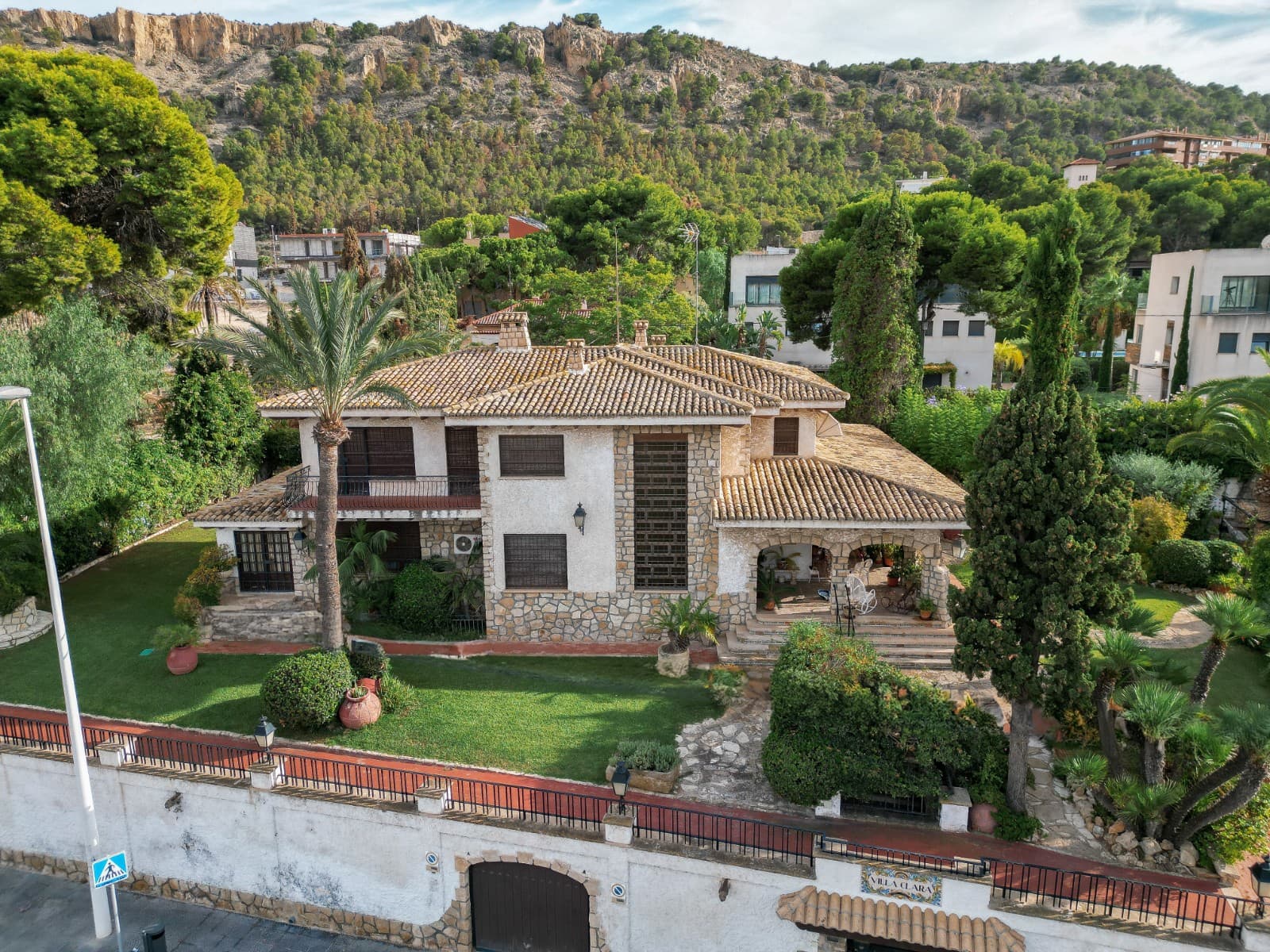 Spectacular Luxury Villa in Albufereta



We present an exclusive luxury villa from the 60s, located on a plot of 1,608 m², with a constructed area of 473 m². Located in an elevated position, this property offers an exceptional level of privacy, ideal for those seeking tranquility in a prime area of La Albufereta, one of the most coveted residential environments.

Architecture and Distribution

The villa stands out for its elegant cobblestone façade, which gives it a timeless and sophisticated style, making it harmoniously integrated with the manicured gardens that surround it.

Lower Floor:

Upon entering, you are greeted by a spacious and bright living room, perfect for family and social gatherings. Next to this space, there is a fully equipped independent kitchen. The floor is completed with 2 bathrooms and 3 large bedrooms, all of them with high quality finishes.

Upper Floor:

On the upper floor there are 5 double rooms, designed to maximize comfort and privacy. The main room stands out for having an en-suite bathroom and a dressing room. In addition, the floor has a service bathroom that complements the functionality of this level.

Outdoor Spaces

The villa's garden is meticulously maintained, providing a green and serene environment that blends with the surrounding nature. The outdoor area has a spacious outdoor dining room, ideal for enjoying family meals or outdoor events, as well as a private pool, perfect for relaxing and enjoying the Mediterranean climate.

Location

Located in the prestigious area of La Albufereta, this villa offers the best of both worlds: the peace and privacy of an exclusive home, combined with proximity to all services and easy access to the beaches and the center of Alicante. La Albufereta is known for being one of the most prime areas of the city, which makes this property a unique opportunity to live in luxury and comfort.