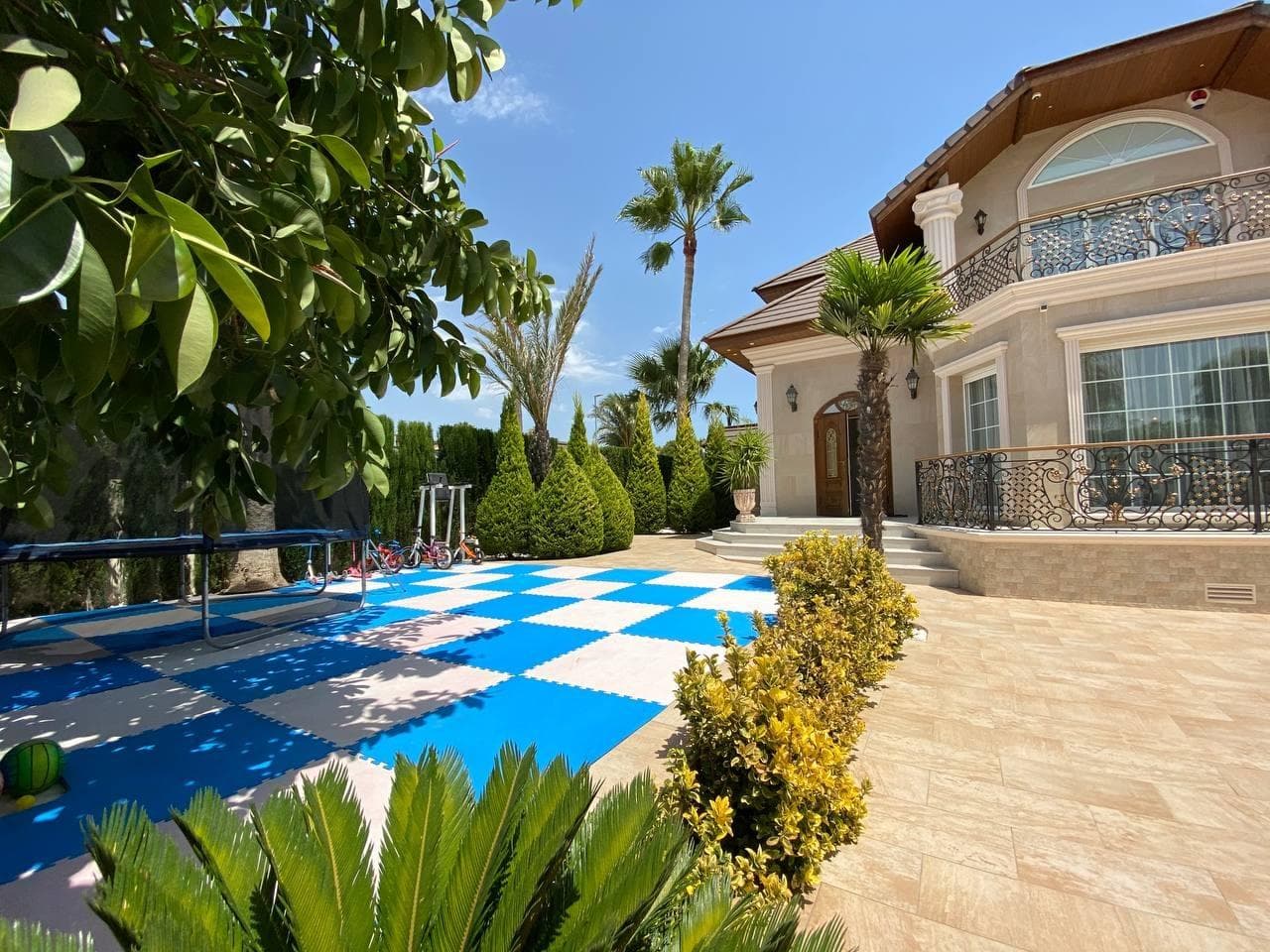 This stunning residence in Ciudad Quesada, located in a tranquil neighborhood, is now available for sale, offering a welcoming and sophisticated living experience. Originally built on a plot of 878 m², with a living area of 313 m², this property was renovated in 2017, incorporating contemporary amenities and a charming landscaped outdoor space. Upon arrival, you are greeted by a lush garden surrounded by trees that provide privacy and serenity. To the right of the entrance, there is a cozy seating area, perfect for relaxing in the shade on sunny days. At the center of the outdoor area lies a pristine swimming pool, ideal for cooling off during the summer. To the left of the pool, a garden with large trees and a hammock invites you to enjoy tranquil moments. Additionally, the space features a modern outdoor kitchen equipped with a dining area, barbecue, sink, and electrical connections, perfect for hosting outdoor dinners with friends and family. As you enter the house, a practical entryway with a built-in closet offers ample space to store clothing and footwear. Directly opposite this area, there is a comfortable guest bedroom with a double bed. To the right, a spacious open-plan living room and kitchen serve as the heart of the home. This bright space includes a large dining table and a modern kitchen with state-of-the-art appliances and ample countertop space, ideal for cooking and socializing. From this main area, you have access to a second bedroom, currently used as a children's playroom, and a modern bathroom with a shower. The living room also connects to a garage and a storage room under the staircase leading to the second floor. On the upper floor, you will find additional functional spaces. To the left, two more bedrooms share a bathroom with a shower; one of them is used as a gym, while the other serves as a children's bedroom with a French balcony. On the opposite side of this floor, the master suite offers a walk-in closet, a spacious bathroom with a shower, a bathtub, and a large private balcony, perfect for peaceful moments of relaxation. The house is equipped with underfloor heating, central air conditioning, and pre-installation for a fireplace, ensuring comfort throughout the year. All windows feature double glazing and electric shutters for enhanced insulation and security. This property is the perfect combination of modern design and a peaceful natural environment, ideal for those seeking comfort, privacy, and a high-quality lifestyle.