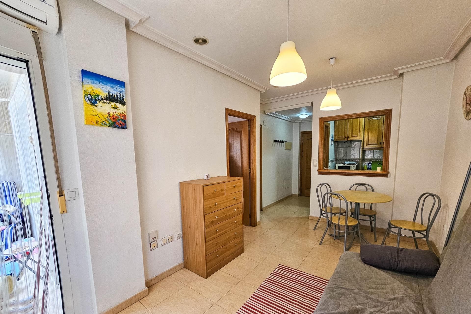 A one-bedroom apartment with a glazed balcony is for sale on Orihuela Street, 60 — right in the heart of Torrevieja. The vibrant city center, everything is nearby: supermarkets, bus stops, a school, the town hall, and the marina. Distance to the sea and beach — only 550 meters in a straight line. The apartment is located on the 2nd floor of a building constructed in 1995, with an elevator and intercom. The windows face southwest, making the apartment bright and dry. Total area — 47 m². Includes an entrance hall, living room with balcony, American-style kitchen, bedroom, and a full bathroom. Sold furnished and with household appliances. Move-in ready.