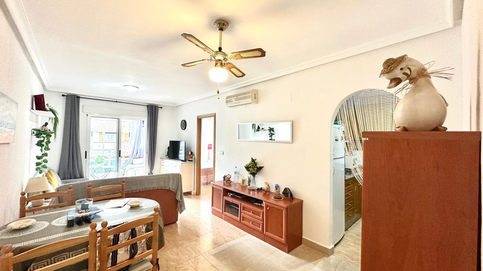 This attractive first-floor apartment is located on Torrevieja's renowned Avenida Habaneras, one of the city's main thoroughfares and just 300 meters from the beach. Its prime location makes it an ideal choice for both a permanent residence and a second home or investment, as it allows guests to enjoy proximity to the sea while also being close to all essential services: supermarkets, restaurants, public transport, and leisure areas. The home boasts a highly functional layout that guarantees comfort and privacy. It features two spacious, well-lit bedrooms and two full bathrooms, one of them en suite, providing added comfort. This feature makes it a practical home for families, couples, or for entertaining guests with complete independence. The south-facing aspect is another of this apartment's great features, as it ensures natural light for virtually the entire day, creating a warm and welcoming atmosphere. The air-conditioned living-dining room is the heart of the home: a comfortable, versatile space designed for enjoyment both in summer and winter. From here, you can access a glazed terrace that offers multiple possibilities, whether as a reading corner, additional dining area, or relaxation area, while also expanding the usable area of ​​the home. The kitchen is separate and equipped with a practical gallery or interior patio used as a laundry and drying area. This detail is especially useful for maintaining order and functionality on a daily basis. The residential complex where the apartment is located offers a communal pool, strategically located on the first floor, which means it can be accessed practically from the front door. This adds comfort and makes this property an ideal place to enjoy sunny days in a safe and family-friendly environment. In short, this is an apartment that meets all the requirements to become a complete home: proximity to the beach, good orientation, excellent common areas, practical layout, and a strategic location in one of the most valued areas of Torrevieja. An opportunity for those seeking quality of life just steps from the sea.