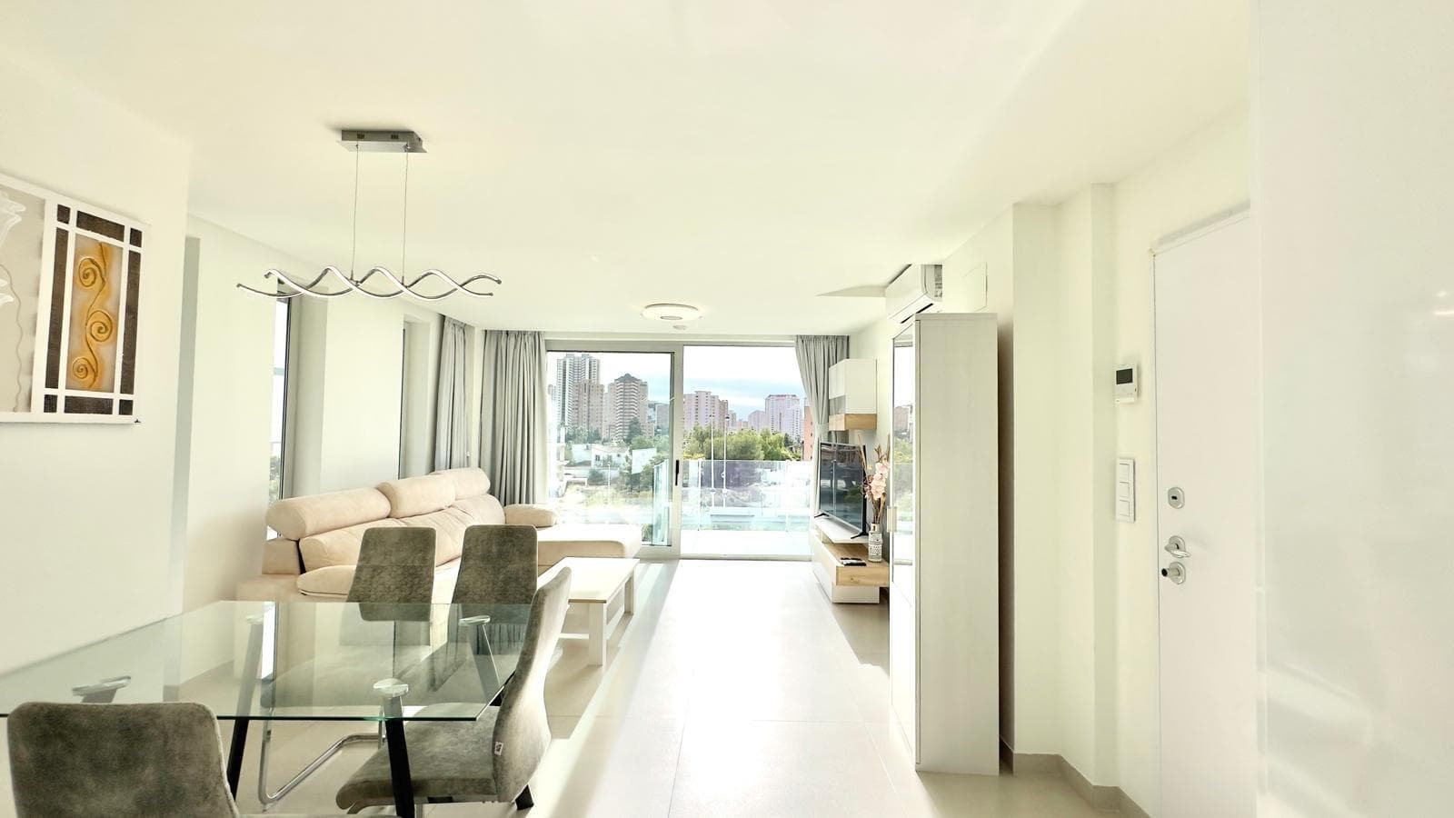 This exclusive first-floor flat, located in the prestigious area of Benidorm, just one kilometre from Cala de Finestrat, is situated in the renowned Oasis Building, a modern development that stands out for its luxurious communal areas and services designed for the well-being and enjoyment of its residents. The complex offers a privileged environment with first-class facilities, including an outdoor communal swimming pool with jacuzzi, an indoor swimming pool, sauna area and areas equipped with exercise machines for common use, providing ideal spaces for both leisure and personal care without having to leave home. The property has a spacious and comfortable layout, with two bedrooms, both with excellent light and comfort. It is worth noting that one of the bedrooms has an en-suite bathroom, offering greater privacy, while the property has a second full bathroom that serves the rest of the property, providing maximum functionality to the whole. The spacious and cosy living-dining room is the main hub of the property, connecting directly to the terrace, a perfect space to enjoy the outdoors and the Mediterranean climate. Thanks to its double west and south orientation, the property receives magnificent natural light throughout most of the day, creating a warm and very pleasant atmosphere in all rooms. The fully equipped open-plan kitchen blends seamlessly with the living room, offering a feeling of spaciousness and comfort. It also has a utility room, providing extra space for laundry or storage, which adds much-appreciated functional value. Overall, this apartment in the Oasis Building in Benidorm represents a unique opportunity for those seeking a superior quality home in an exclusive residential setting, with comprehensive communal areas and a privileged location near the sea. Ideal as a primary residence, second home or high-end investment in one of the most sought-after areas of the Costa Blanca. Translated with DeepL.com (free version)