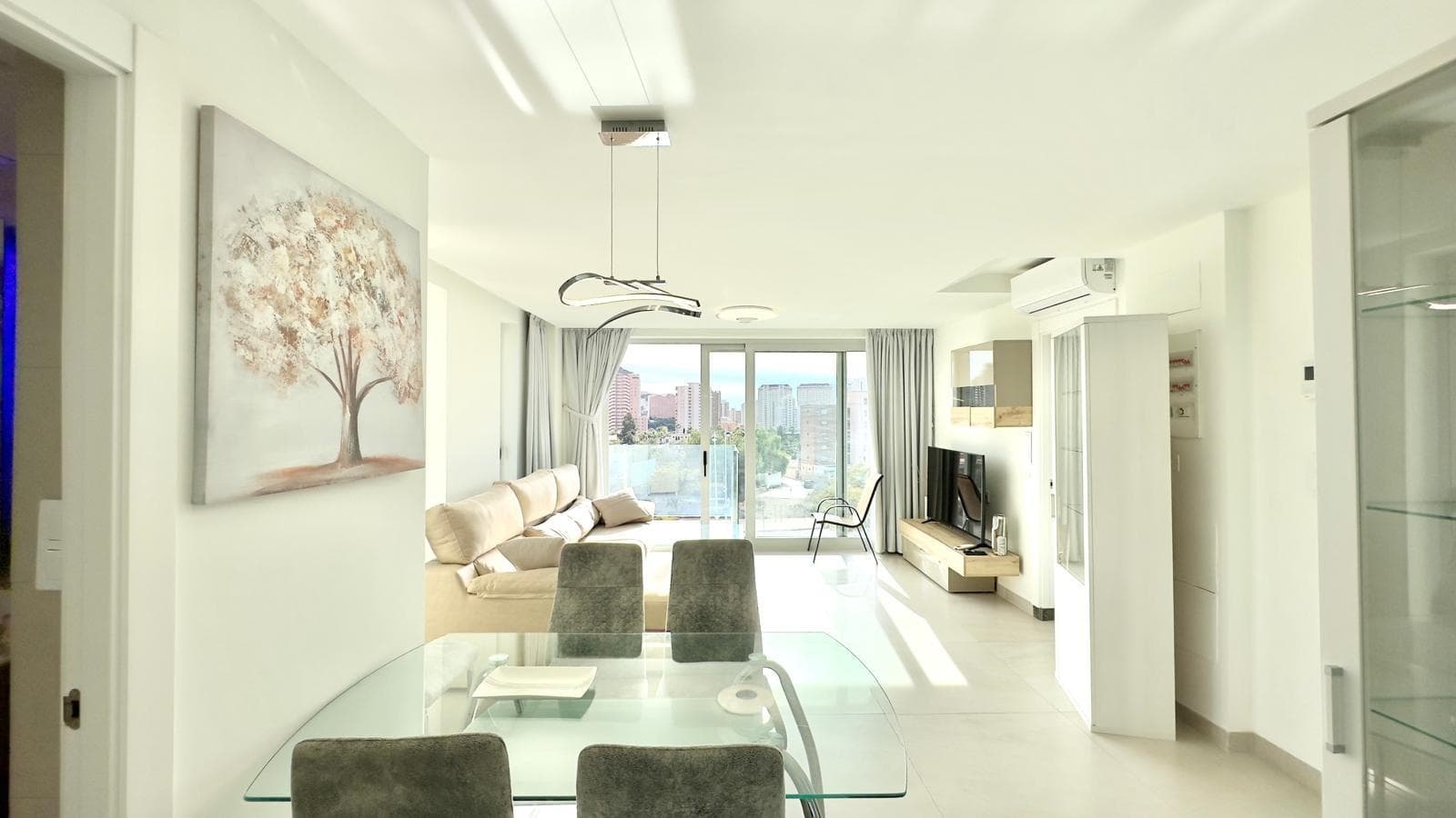 This exclusive second-floor flat, located in the prestigious area of Benidorm, just one kilometre from Cala de Finestrat, is located in the renowned Oasis Building, a modern development that stands out for its luxurious communal areas and services designed for the well-being and enjoyment of its residents. The complex offers a privileged environment with first-class facilities, including an outdoor communal swimming pool with jacuzzi, an indoor swimming pool, sauna area and areas equipped with exercise machines for common use, providing ideal spaces for both leisure and personal care without having to leave home. The property has a spacious and comfortable layout, with two bedrooms, both with excellent light and comfort. It is worth noting that one of the bedrooms has an en-suite bathroom, offering greater privacy, while the property has a second full bathroom that serves the rest of the property, providing maximum functionality to the whole. The spacious and cosy living-dining room is the main hub of the property, connecting directly to the terrace, a perfect space to enjoy the outdoors and the Mediterranean climate. Thanks to its double west and south orientation, the property receives magnificent natural light throughout most of the day, creating a warm and pleasant atmosphere in all rooms. The fully equipped open-plan kitchen blends seamlessly with the living room, creating a feeling of spaciousness and comfort. It also has a utility room, providing extra space for laundry or storage, which adds much-appreciated functional value. Overall, this second-floor flat in the Oasis Building in Benidorm represents a unique opportunity for those seeking a superior quality home in an exclusive residential setting, with comprehensive communal areas and a privileged location near the sea. Ideal as a primary residence, second home or high-end investment in one of the most sought-after areas of the Costa Blanca.