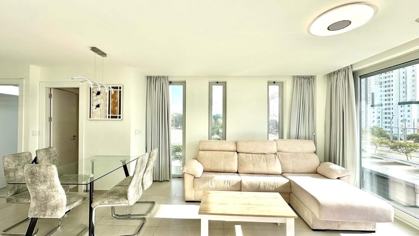 This magnificent apartment, located on the third floor of one of Benidorm's most exclusive residential complexes, offers a privileged setting just one kilometer from Finestrat Cove, one of the most sought-after areas for those seeking tranquility without sacrificing proximity to the sea and all amenities. The residential complex in which the property is located stands out for its impressive range of communal areas, designed to provide a truly luxurious residential experience. Facilities include an outdoor swimming pool surrounded by perfectly maintained gardens, a heated pool ideal for year-round enjoyment, a jacuzzi, a sauna, and spaces designed for wellness and relaxation. All this creates an exclusive, safe, and comfortable environment that enhances the value of the property. The apartment has a modern and functional layout that maximizes the spaciousness and brightness in each room. It has two bedrooms, both of excellent size, and two bathrooms, one of which is en suite, equipped with elegant, high-quality finishes. The living-dining room stands out for its spaciousness and natural light, enhanced by its south-facing orientation, which guarantees direct light for most of the day. The open-plan American-style kitchen, integrated into the living room, adds a contemporary and practical touch, providing a perfect space for both everyday living and social gatherings. Thanks to its privileged location, the property is surrounded by all essential services, such as supermarkets, shopping centers, restaurants, public transport, and leisure areas, making this apartment an exceptional option both as a primary residence and as an investment or second home. Overall, this property represents a unique opportunity to acquire a home in one of the most exclusive areas of the Costa Blanca, combining comfort, design, exclusivity, and a first-class environment.