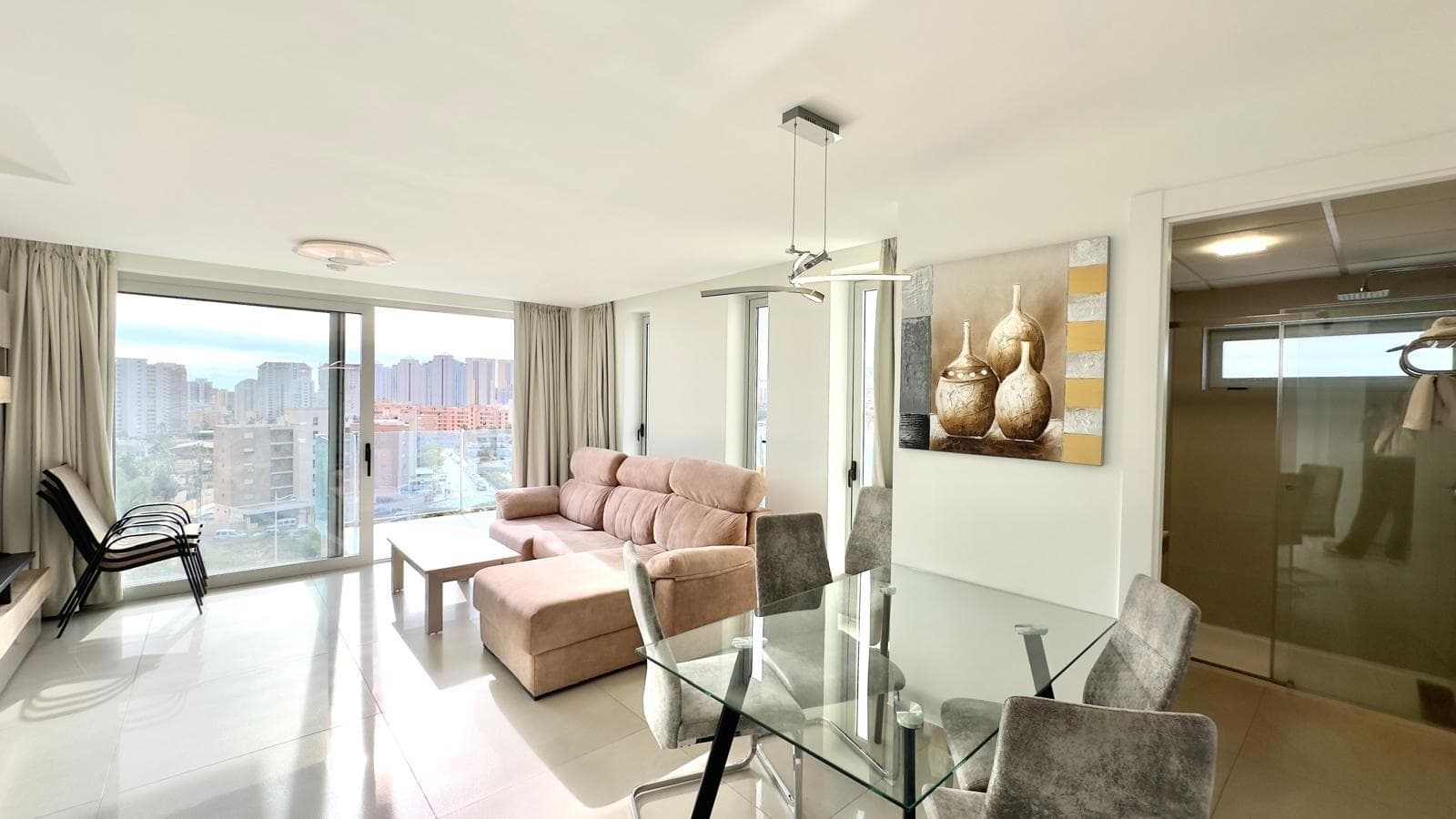 Third-floor apartment in a luxury development in Benidorm, less than 1,200 meters from the beach, with 2 bedrooms and 2 bathrooms. This property captures the vibrant essence of the Costa Blanca, offering an exclusive retreat for those who want to immerse themselves in Mediterranean charm without unnecessary complications. Charm of the Location Benidorm shines as an iconic destination, where the hustle and bustle of the beach blends with serene corners of refined residential areas. Just a short walk from Levante beach, this property invites you to enjoy the eternal sun, gentle waves, and the salty aroma that permeates the air. The proximity to the lively heart of the city allows you to explore terraces with sea views, local markets brimming with freshness, and trails that wind their way to hidden coves, all while remaining in a privileged enclave of elevated tranquility. The third floor offers captivating views of the blue horizon, where sunsets paint the sky in shades of pink and orange, creating unforgettable moments from the privacy of your home. Surrounded by palm trees swaying in the breeze and lush gardens, the development evokes a private paradise, ideal for disconnecting from the outside world and recharging your batteries in an environment that exudes discreet luxury and coastal authenticity. Cozy Interior Atmosphere Upon crossing the threshold, a bright entrance hall welcomes you, flowing into open spaces that encourage connection and everyday comfort. The living-dining room becomes the epicenter of family or social life, bathed in natural light that pours in, inviting long conversations around the table or lazy afternoons overlooking the outdoors. The integrated kitchen is a functional and harmonious space, perfect for preparing home-cooked meals while chatting with guests or keeping an eye on the horizon. The two bedrooms offer personal retreats: the master bedroom is a spacious sanctuary where deep rest becomes a reality, with enough space to personalize it to your liking. The second bedroom is versatile and bright, suitable for guests, a reading corner, or a creative space, always with a warmth that invites you to stay. The two bathrooms complete the harmony, designed for smooth daily routines and moments of relaxation, with a touch of elegance that elevates the everyday to the extraordinary. Life in the Development Integrated into a select community, this development prioritizes collective well-being with common areas that transform everyday life into a pleasant experience. The main pool invites refreshing swims under the sun, while landscaped areas provide shade and coolness for spontaneous gatherings. Spaces dedicated to sports and leisure encourage an active lifestyle, from friendly games to outdoor exercise sessions, all wrapped up in security and absolute privacy. Subtle community events strengthen the bonds between neighbors, creating a sense of belonging that enriches the stay. The strategic location facilitates quick trips to Benidorm's iconic attractions, such as adrenaline-filled theme parks or nature trails that awaken the senses, turning every day into a new accessible adventure. Ideal for Investment and Enjoyment This property stands out as a profitable opportunity in a dynamic market like Benidorm, where demand for vacation stays and premium residences is unrelenting. Owners find it to be an asset that generates immediate satisfaction, whether renting it to tourists delighted by its proximity to the sea or enjoying it as a personal weekend getaway. The constant flow of European and domestic visitors ensures economic vitality, with potential for sustained appreciation thanks to the area's enduring appeal. For families or couples, it represents the perfect balance between urban proximity and residential peace, with easy access to essential services and varied leisure activities. European retirees