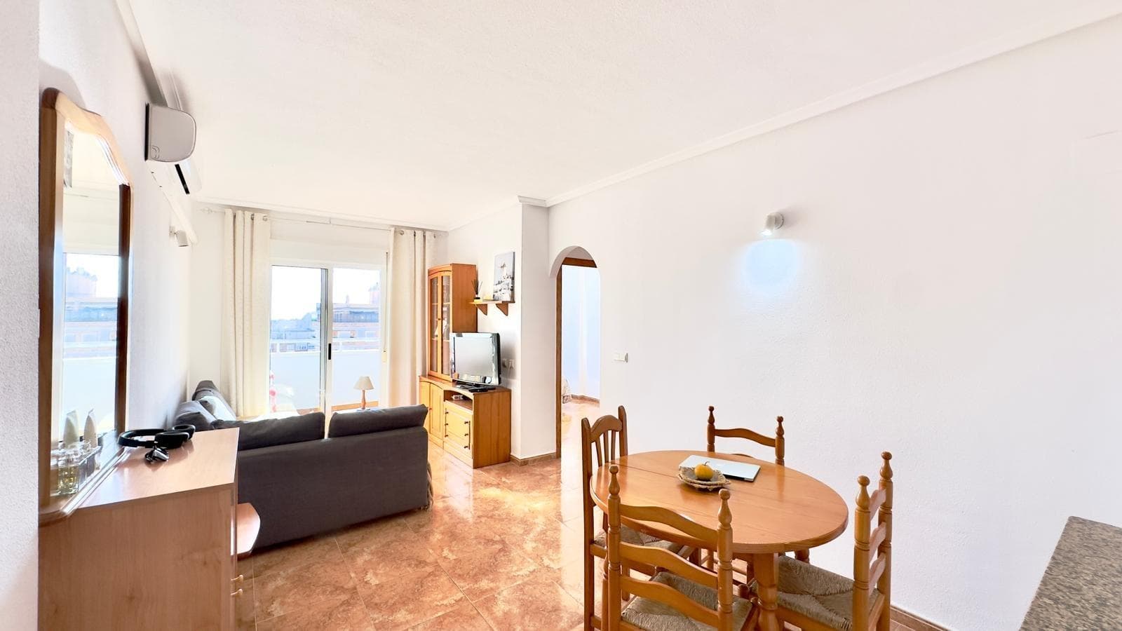 Two-bedroom, one-bathroom apartment with a terrace located in the heart of Torrevieja, designed for those who want everything within easy reach without sacrificing a comfortable space to unwind at the end of the day. Its location places the property in the city center, surrounded by amenities, urban life, and the Mediterranean essence that characterizes this coastal town. Living in the center of Torrevieja Living in the center of Torrevieja means being just steps away from shops, cafes, restaurants, and all kinds of services that make daily life easier. The streets are bustling year-round, with a constant flow of residents and visitors enjoying the promenades, terraces, and proximity to the sea. The area combines residential buildings with small local businesses, markets, and convenience stores, allowing you to meet any need without having to travel far. Furthermore, its connection to the main avenues and the seafront promenade makes getting around the city quick and easy, both on foot and by public transport. A welcoming and functional space The apartment is designed as a practical home, with a layout that makes good use of the available space to create a welcoming atmosphere. The living area is organized around the living room and terrace, clearly separating the spaces for relaxation from those intended for socializing within the home. The two bedrooms offer versatility, as they can be used as a master bedroom and a secondary bedroom, a guest room, an office, or a multifunctional space depending on the needs. This layout makes the apartment an attractive option for couples who need an extra room, as well as for small families looking for a comfortable and well-located place. A terrace as an extension of the home The terrace becomes one of the apartment's most special features, functioning as a natural extension of the living room and as a small private oasis in the heart of the city. It's an ideal space for a table and chairs, creating a reading nook, or simply enjoying the fresh air at the start or end of the day. This outdoor space provides a sense of openness that is especially valued in a centrally located home, allowing you to enjoy Torrevieja's mild climate for much of the year. Both in winter and summer, the terrace offers the opportunity to experience the city from home, observing the activity on the streets without sacrificing the privacy of your own home. Urban Environment and Lifestyle The center of Torrevieja is characterized by its dynamic atmosphere, with a mix of local residents, national and international visitors, resulting in a diverse and cosmopolitan environment. This diversity is reflected in the culinary offerings, with Mediterranean restaurants, traditional bars, and modern establishments that bring life to the area day and night. Living in this apartment allows you to enjoy proximity to key locations such as the seafront promenade, the port, iconic squares, and pedestrian areas where events, fairs, and cultural activities are held throughout the year. The city combines maritime tradition with modern amenities, creating an appealing balance between Mediterranean charm and urban comfort. Connection to the sea and nature From the city center, you can easily reach some of Torrevieja's most famous beaches and coves, as well as its seaside promenades. This proximity allows you to enjoy swimming, sunset strolls, or water sports without having to travel long distances, something highly valued by those who appreciate frequent contact with the Mediterranean. In addition to the sea, the surrounding area boasts natural spaces of great interest, such as the La Mata and Torrevieja Lagoons Natural Park, which offers trails, viewpoints, and areas for enjoying nature.