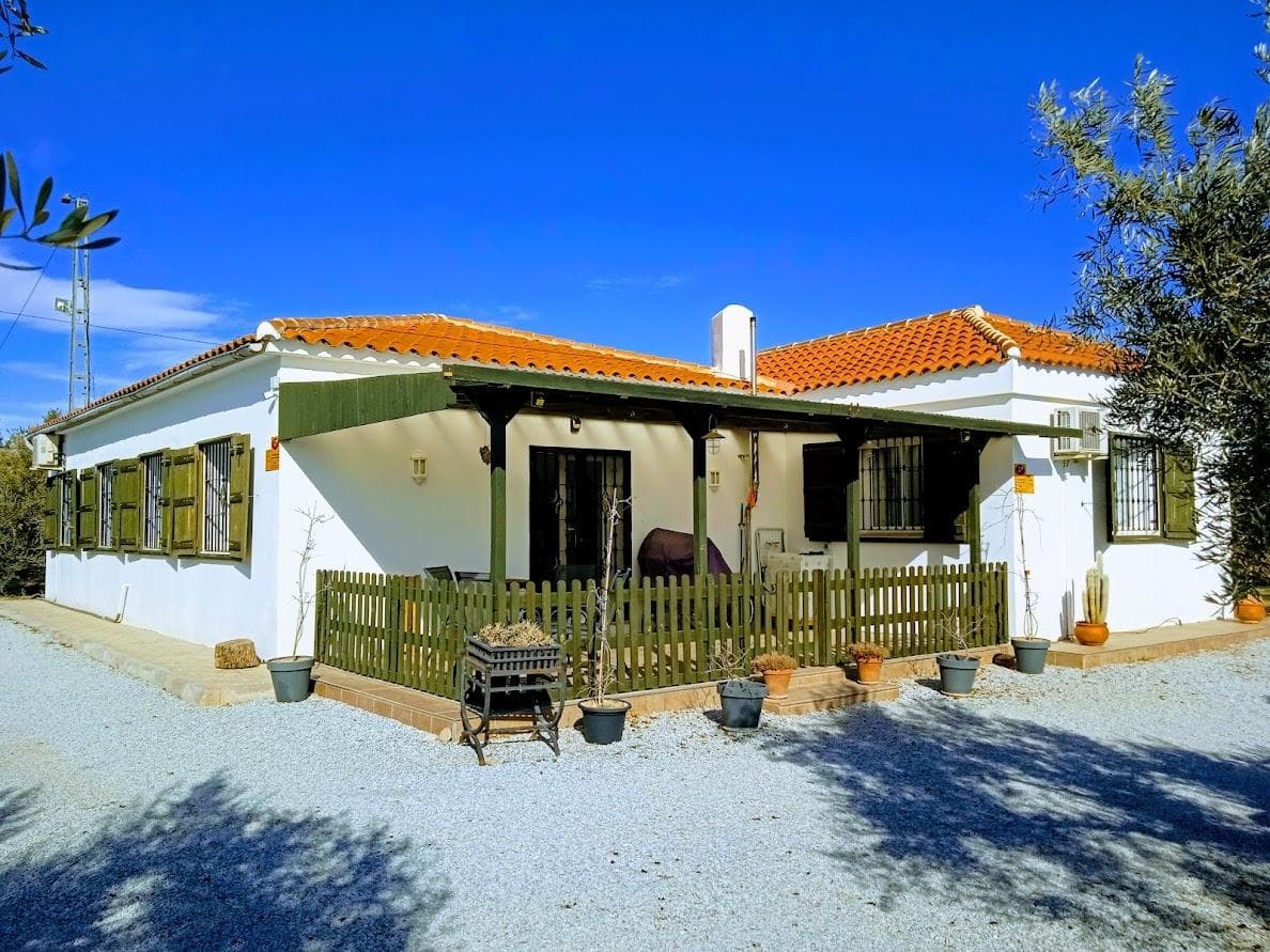 This beautifully maintained chalet, located just a 2-minute drive from the vibrant town of Baza, offers the perfect blend of rustic charm and modern comfort. Accessible via tarmac road and a private gate, this home has been cherished by its owners for over 20 years and has been renovated and maintained to a high standard. The craftsmanship shines in its hand-built features, such as the bespoke country-style kitchen, built-in wardrobes, and handmade exterior shutters. Interior Highlights •Living Room: Bright and spacious, leading to the rest of the home. •Master Bedroom: Generously sized with modern en-suite featuring a walk-in shower and hand-crafted built in wardrobes. •Second Bedroom: Comfortable double room located next to the main bathroom. •Kitchen and Dining Area: A cozy space showcasing traditional woodwork. •Comfort Features: Insulated walls and floors for energy efficiency, double-glazed windows with mosquito nets, hot/cold AC in the kitchen and master bedroom, and a pellet burner in the living room (convertible to an open fireplace). Outdoor Features •Extensive Land: Spanning 8231 m² (approximately 2 acres), the property includes: •220 Olive Trees: Well-maintained and actively producing. •220 Almond Trees: Carefully nurtured. •Fruit Trees: A variety of young trees adding to the charm. •Vegetable Garden & Chicken Hut: Perfect for sustainable living. •Outbuilding: A large garage with storage and separate entrance to a workshop, ample space for hobbies or projects. •Private Terrace: Covered outdoor space for relaxation or entertaining. Proximity to Nature and Local Attractions Surrounded by serene olive groves and almond fields, the home offers privacy without sacrificing convenience. Nearby attractions include: •Baza Town: Explore its rich history, vibrant markets, and amenities like shops, restaurants, schools, and health centers. Don't miss the iconic "Fiestas de Cascamorras" or the Baza Archaeological Museum. •Negratin Reservoir: Just a short drive away, enjoy non-motorized water sports, scenic views, and a mix of traditional and nudist beaches. •Sierra de Baza Natural Park: Perfect for hiking, bird-watching, and immersing in nature. Accessibility •Nearest Airports: oGranada Airport: Approximately 1 hour by car. oAlmeria Airport: Around 1.5 hours away. oMalaga Airport: Roughly 2 hours and 15 minutes for international connections. Endless Potential This home is ideal for those seeking tranquility and self-sufficiency while remaining close to urban conveniences. Whether you're drawn to farming, enjoying nature, or simply relishing the beauty of rural Spain, this property offers boundless opportunities. Viewings are highly recommended to truly appreciate this exceptional property. Contact us today to arrange a visit!