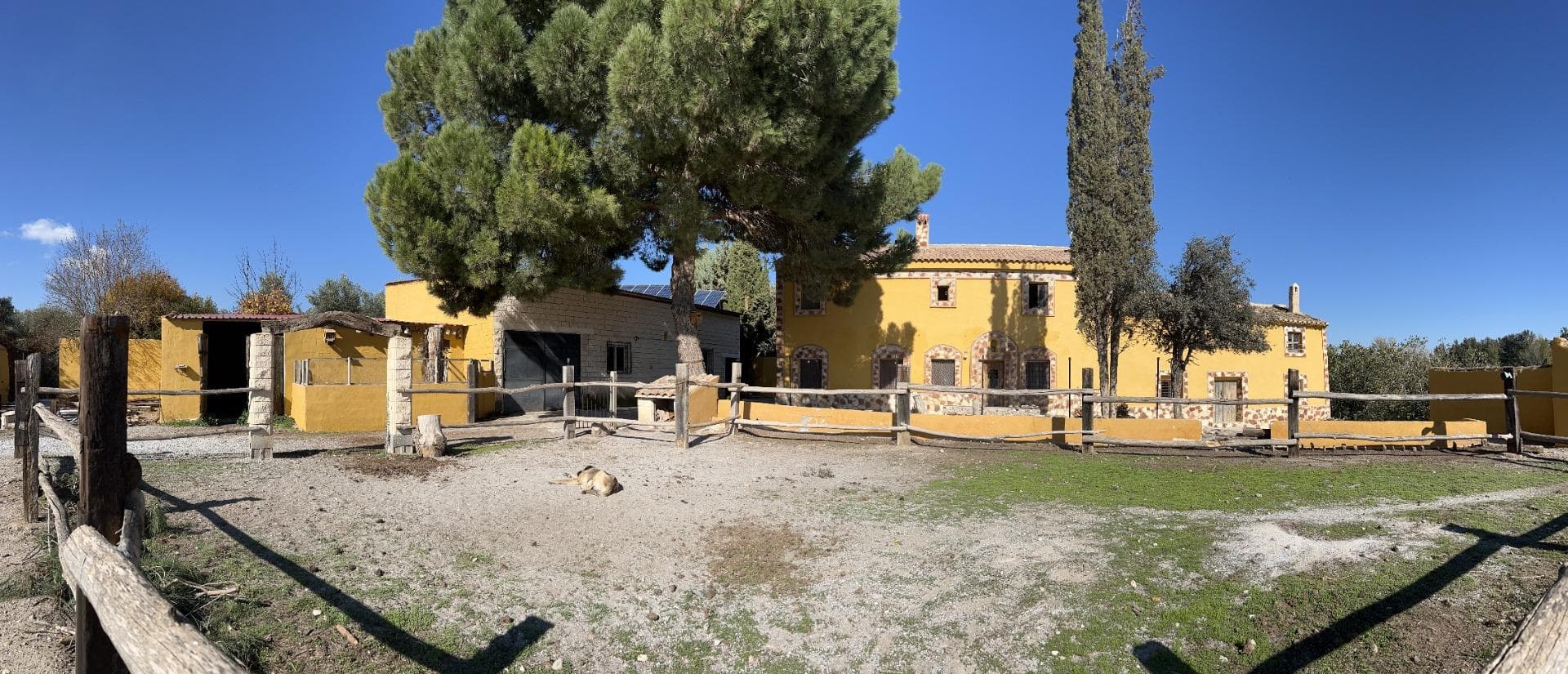 Nestled in the tranquil Andalusian countryside, this exceptional cortijo sits on a sprawling 2.4-hectare plot (approximately 5.93 acres), just 5 km from the vibrant market town of Baza. Surrounded by breathtaking natural beauty, the property is fully fenced, ensuring complete privacy with no neighbors or disturbances. Accessible via a tarmac road with a well-maintained track for the last 800 meters, this cortijo offers an unparalleled combination of rustic charm and modern convenience. This estate is ideal for a variety of lifestyles and ventures, from a serene family retreat to an equestrian center or a thriving rural tourism complex. With an equestrian license (OCU license) in place for up to five horses, this property is a haven for animal lovers and horse enthusiasts. Key Features: The Property. The cortijo boasts two independent, fully renovated 2 storey farmhouse, a vast stable with a hay loft, and a private swimming pool set in a stunning courtyard. Main House: Upon entering, a spacious hall welcomes you, leading to: An open-plan kitchen and dining area with a wood burner. A lounge with access to the enchanting courtyard, featuring seating areas, an outdoor kitchen, and a bar and the pool. Three storage rooms, which can easily be transformed into additional accommodation. A cozy library/lounge with an open fireplace, a large dining room, and a versatile living room that could serve as a ground-floor master bedroom with an en-suite shower room. Upstairs, you'll find a huge family bathroom with a luxurious corner tub and four large double bedrooms, currently utilized as living spaces and storage. Guest House: This charming residence features: A large entrance hall, two bedrooms, a fully equipped bathroom, a spacious living room with a fireplace, and a kitchen with courtyard access. The private courtyard connects to the swimming pool and includes a staircase to a roof terrace with stunning views. The upper floor houses a massive, open-plan games and entertainment room – the perfect "man cave" or party space. Additional storage rooms, with the potential to be converted into a 2-bedroom apartment. Additional Structures: A single-story workshop, currently used as an art studio. A donkey barn and chicken hut attached to the spacious stable. The Land. The terraced, irrigated land offers immense opportunities for farming, equestrian activities, or even developing a stunning wedding venue. Currently, the property includes: Ample space for horse paddocks. Flat terraces for growing fruits and vegetables or raising animals. Off-Grid Living. This property is entirely self-sufficient, powered by a modern solar energy system with a battery storage unit housed in the stables. Unlimited water is supplied by a council-maintained well, ensuring sustainable and cost-effective living. Location Highlights: The cortijo is located a short 10-minute drive from Baza, a lively market town rich in history and amenities, including supermarkets, healthcare facilities, schools, and restaurants.