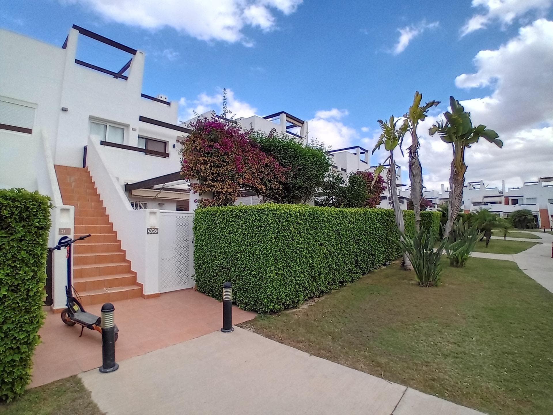 Looking for a home that blends comfort, convenience and situated in the perfect location? This 3 bed, 1 bath ground floor apartment in the popular location of Naranjos 1 garden has it all. Step inside to a bright, open-plan living space that flows onto a private back terrace with added privacy screens (perfect spot for a jacuzzi) and a pretty front garden framed with vibrant jasmine and bougainvillea plants. Whether you’re in the mood for sunbathing, al fresco dining, or pure relaxation – this apartment has you covered. Naranjos 1 is one of the most desirable spots on the resort – just a 3-minute stroll to shops and restaurants, yet tucked away in a peaceful pocket with manicured gardens and a pool just 100m away at Naranjos 2. The best of both worlds. Why you’ll love it: 3 double bedrooms + 1 family bathroom Private terraces front & back with enhanced shutters Air conditioning & ceiling fans throughout Communal pool just around the corner Secure, gated community with 24/7 security Resort facilities: supermarket, restaurants, sports courts & Jack Nicklaus golf course All of this just 20 minutes away from Mazarrón’s golden beaches and less than 30 mins to Murcia Airport. Perfect for holidays, rentals, or full-time living under the Spanish sunshine.