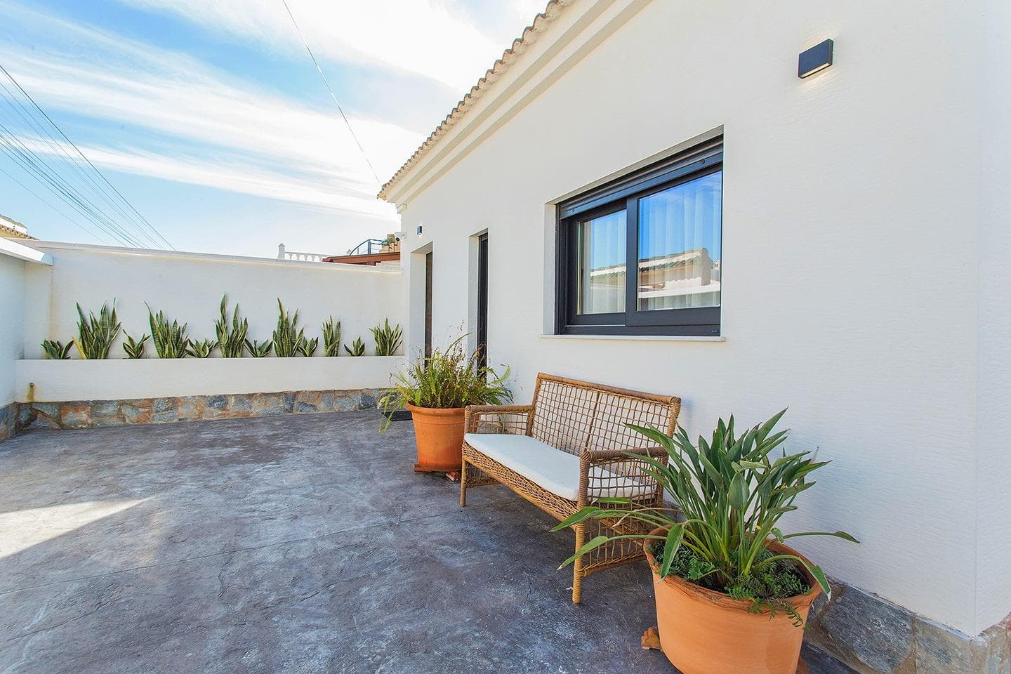 Welcome to this beautifully renovated villa in the sought-after El Chaparral neighborhood of Torrevieja. Combining contemporary design, cutting-edge technology, and the warmth of Mediterranean living, this property is perfect for a relaxed lifestyle on the Costa Blanca. Designed with both comfort and functionality in mind, the villa offers a seamless layout. Upon entering, a welcoming hallway connects to the bedrooms on one side and leads into the open-plan dining area and kitchen. The stylish, fully equipped kitchen is perfectly situated next to a covered patio with ceiling fans, creating an ideal setting for outdoor dining. The home features three spacious bedrooms and two sleek, modern bathrooms, both equipped with electric blinds for added convenience. The living room also benefits from electric blinds, allowing for effortless privacy and light control. Step outside and enjoy the villa’s southwest-facing garden, designed for low maintenance and maximum relaxation. A private pool serves as the centerpiece, complemented by a covered terrace perfect for lounging and entertaining. Additional patio areas and a separate storage room enhance the home’s practicality. This villa is equipped with top-tier modern amenities, including ducted air conditioning throughout, solar panels providing power for both electricity and hot water, and underfloor heating in the bathrooms. A security camera system offers additional peace of mind. Fully furnished and move-in ready, the home also boasts built-in wardrobes and ceiling fans for added comfort. Whether you’re searching for a tranquil family retreat or a stylish holiday getaway, this villa has it all. Nestled in a quiet yet well-connected location, you’ll have easy access to all that Torrevieja and the Costa Blanca have to offer.
