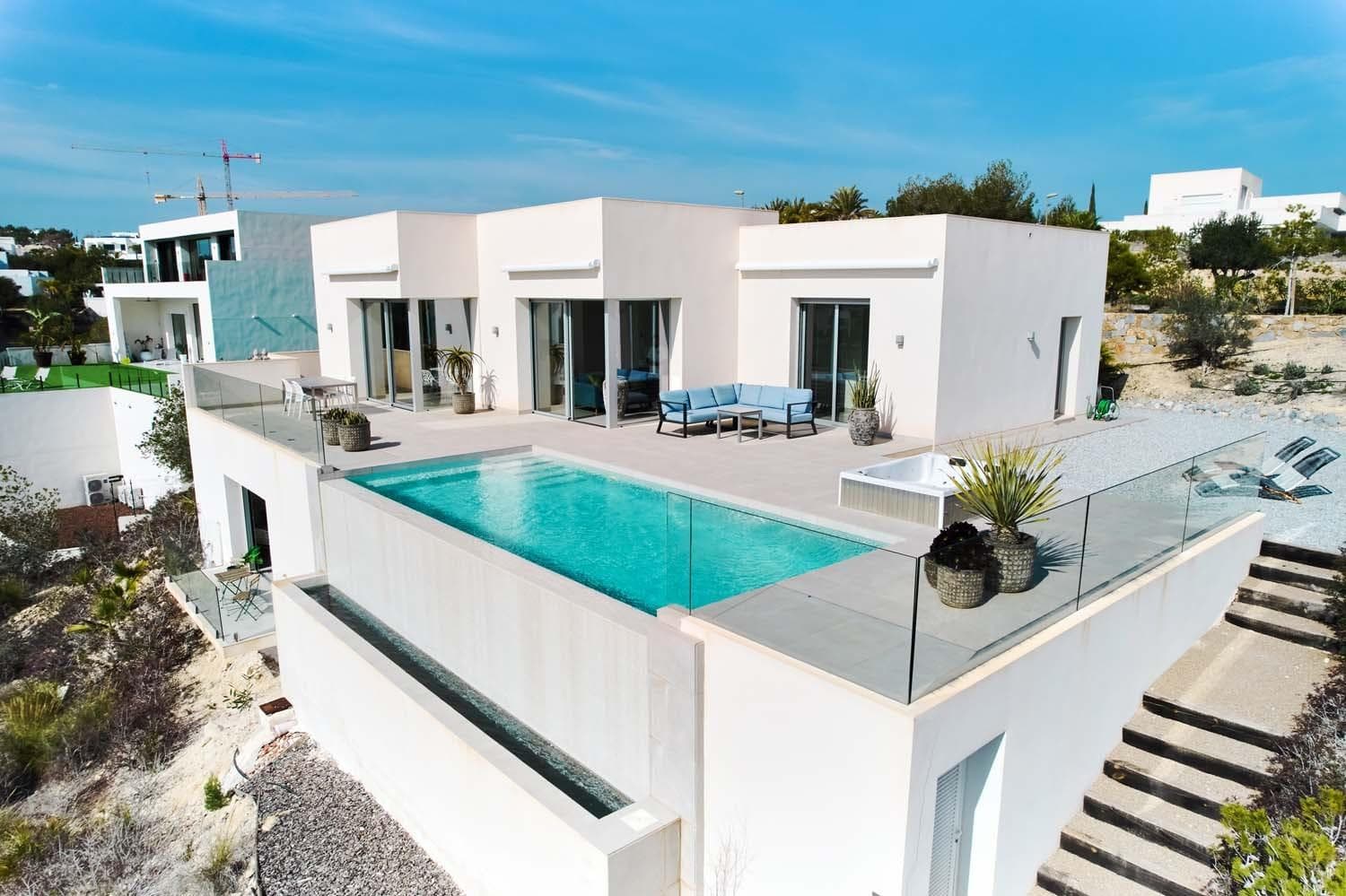 Exclusive, modern villa located on the award-winning Las Colinas Golf & Country Club, one of Europe’s most prestigious resorts. Set on a generous 1,707 m² plot, the property offers complete privacy, a south-facing orientation, and breathtaking panoramic views over the golf course and the sea. The villa features 3 spacious bedrooms, 2 luxury bathrooms, a bright open-plan living area, and a fully equipped designer kitchen. Large sliding doors create a seamless connection between indoor and outdoor living. The expansive terrace with infinity pool and jacuzzi makes this home perfect for relaxation and enjoyment all year round. A large underbuild with its own bathroom and terrace offers excellent potential for additional bedrooms or a self-contained guest apartment. High-quality finishes include zoned air conditioning, underfloor heating in the bathrooms, electric sun blinds, and premium windows. As an owner, you benefit from 24/7 security, exclusive sports and wellness facilities, and access to the private beach club. Ideally located close to beaches, fine dining, and international airports. A unique opportunity for those seeking luxury living, strong investment value, and an exceptional lifestyle on the Costa Blanca.