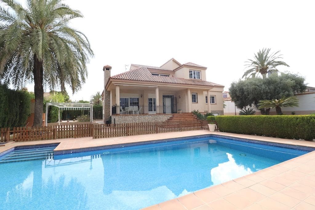 Mil Palmeras – Detached Villa with Large Plot Just 300 m from the Beach. . We present this magnificent detached villa located in the prestigious area of Mil Palmeras, just 300 meters from the sea. The property sits on a generous 1,000 m² plot and offers approximately 350 m² built, distributed over two floors plus a basement/garage.. . Key Features:. . - 4 spacious double bedrooms and 3 full bathrooms, offering comfort and space for the whole family.. - Split-level living and dining room, bright and elegant, creating a sense of openness and style.. - Large independent kitchen, fully equipped, with an adjacent laundry area.. - On the upper floor, a second lounge with pool table and private bar, perfect for leisure and entertaining guests.. - Three terraces surrounding the house, ideal for enjoying the Mediterranean climate year-round.. - Basement with garage for two vehicles and an additional wine cellar/storage room.. - Extensive garden with barbecue area, pergola, and a large private swimming pool, perfect for relaxing or entertaining.. . This exceptional villa combines privacy, generous space, and an unbeatable location, making it ideal as a permanent residence or a solid investment in one of the Costa Blanca's most sought-after areas..