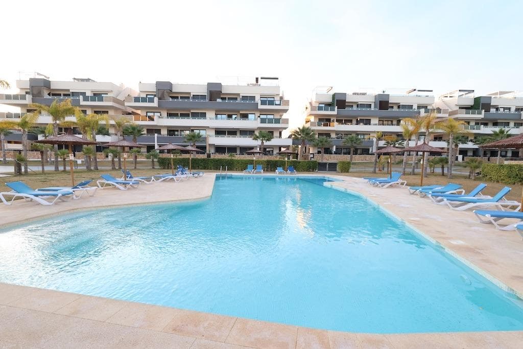 Playa Flamenca, Residencial Amanecer de Luxe: Second-floor apartment (81 m2) with sea and pool views. Features 2 bedrooms, 2 bathrooms (1 en-suite), and an open-plan kitchen/living area leading to a large terrace. Includes storage, garage, and access to a gym and BBQ area. Sold fully furnished.