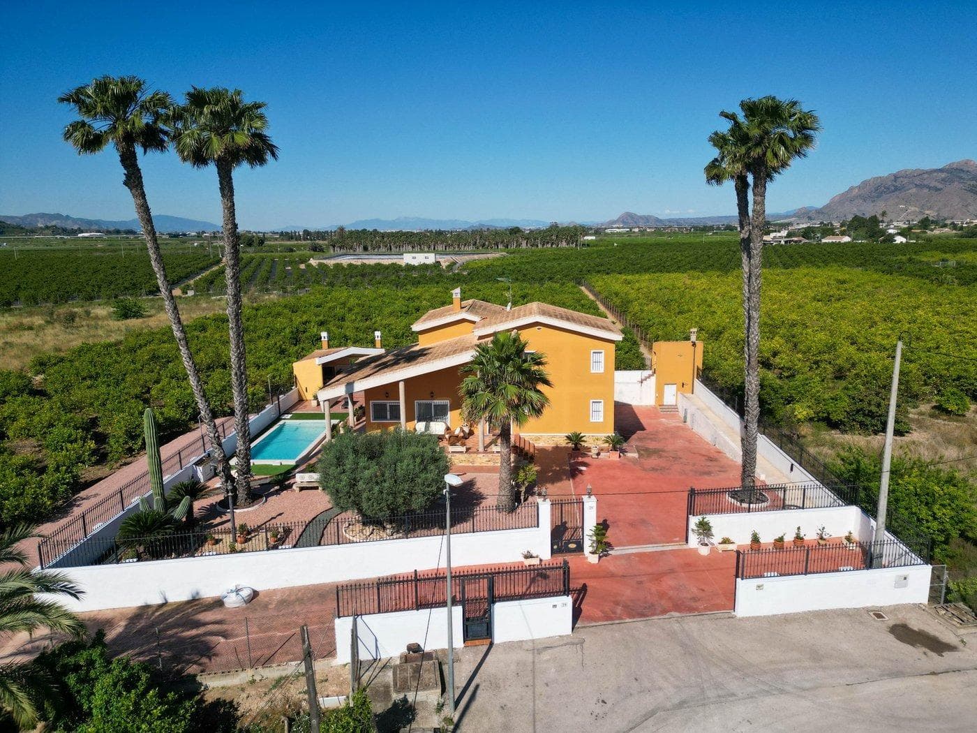 9,480 m2. fully fenced property with 495 m2. house built on a plot of 1,000 m2. all fenced within the perimeter of the property. The house is composed of three floors: - SEMI-BASEMENT FLOOR: 224 m2. Constructed Garage for several vehicles, gym with shower, entertainment area, DIY area with shelves and bench, a bedroom, and a dressing room-shoe closet. - GROUND FLOOR: 178 m2. Constructed Distributed in large living room, large kitchen with access to an outdoor barbecue area, separate pantry, laundry area with access to an outdoor terrace, 1 bathroom with shower, 1 bedroom with built-in closet and an office-room with access to an outdoor terrace.  - SECOND FLOOR: 93 m2. Constructed Distributed in a lookout area to the living room downstairs, master bedroom with balcony, bathroom with whirlpool tub and dressing room, 2 more bedrooms (one with built-in closet) and an extra bathroom with bathtub. AMENITIES Central heating with boiler with water radiators and air conditioning ducts both throughout the house. Outdoor shed with air conditioning engines, heating boiler and gas-oil tank for maintenance. Grilles on all doors and windows with mosquito nets. Installation of Fiber Optic Internet. Building with access from the kitchen for a barbecue area with sink and oven. Swimming pool and garden with outdoors lighting. Access gates to the property and garage with motorized doors. The house is surrounded with a planted land with lemon verna in production and with traditional method of irrigation. PROPERTY LOCATION The property is in a quiet area, 5 minutes from the Carrefour shopping center and town center of Orihuela and Bigastro with good access by road and well connected to both towns. The house is surrounded by residential homes of similar characteristics, and it has an easy access by road and in its surroundings where you can find supermarkets, restaurants, and all necessary services.