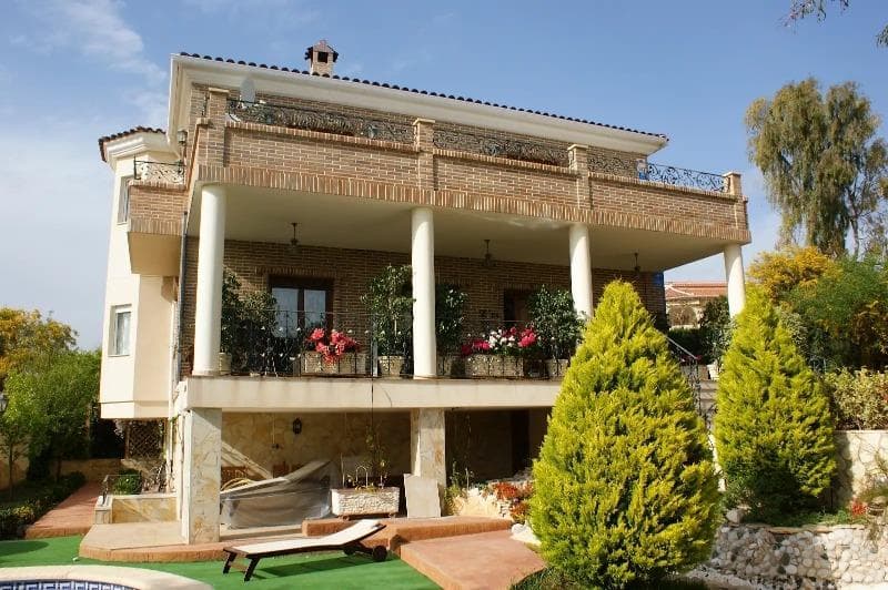 Magnificent and fully detached 3-story luxury villa on a large plot with its own swimming pool and surrounded by gardens in Ciudad Quesada. When you enter the house, you will find a porch with a large terrace (approximately 35 m2). The main floor consists of an entrance hall, a very spacious and bright sitting room with a fireplace, a living room, a dining room, a large independent kitchen equipped with all appliances and access to the barbecue area and the garden, and a bathroom. From there, a marble staircase leads to the upper floor. The upper floor consists of three double bedrooms, a study (which can be converted into a bedroom or other) and two bathrooms (one en-suite with a whirlpool bath to the master bedroom). From the bedrooms, you can access a large terrace with magnificent views of the park and surroundings. The villa also has a basement (access via an internal staircase) with a bedroom, a sauna with a relaxation room and steam shower, a bathroom, and a laundry room. From the basement, you can access the pool area. Contemporary and very elegant style. Large windows. Air conditioning. Fuel-fired heating system that also provides hot water. Built-in wardrobes in the bedrooms. Solid wood kitchen furniture with granite countertops. Stoneware floor and oak parquet. Video surveillance security system. Very High-quality materials. Lots of natural light. All surrounded by a beautiful garden with fruit trees, Mediterranean plants, a small pond with a waterfall, very charming! With a swimming pool and jacuzzi, a large semi-open porch for a barbecue area, a Summer kitchen, a pergola, a parking area for vehicles and a storage room. This splendid villa has been carefully designed for maximum comfort, relaxation and privacy. Excellent location, peaceful surroundings, close to all amenities, restaurants, supermarkets, banks, medical centers, schools, Aquapark, La Marquesa Golf Course, and so on., about a 10- to 15-minute drive from the magnificent beaches of Guardamar.