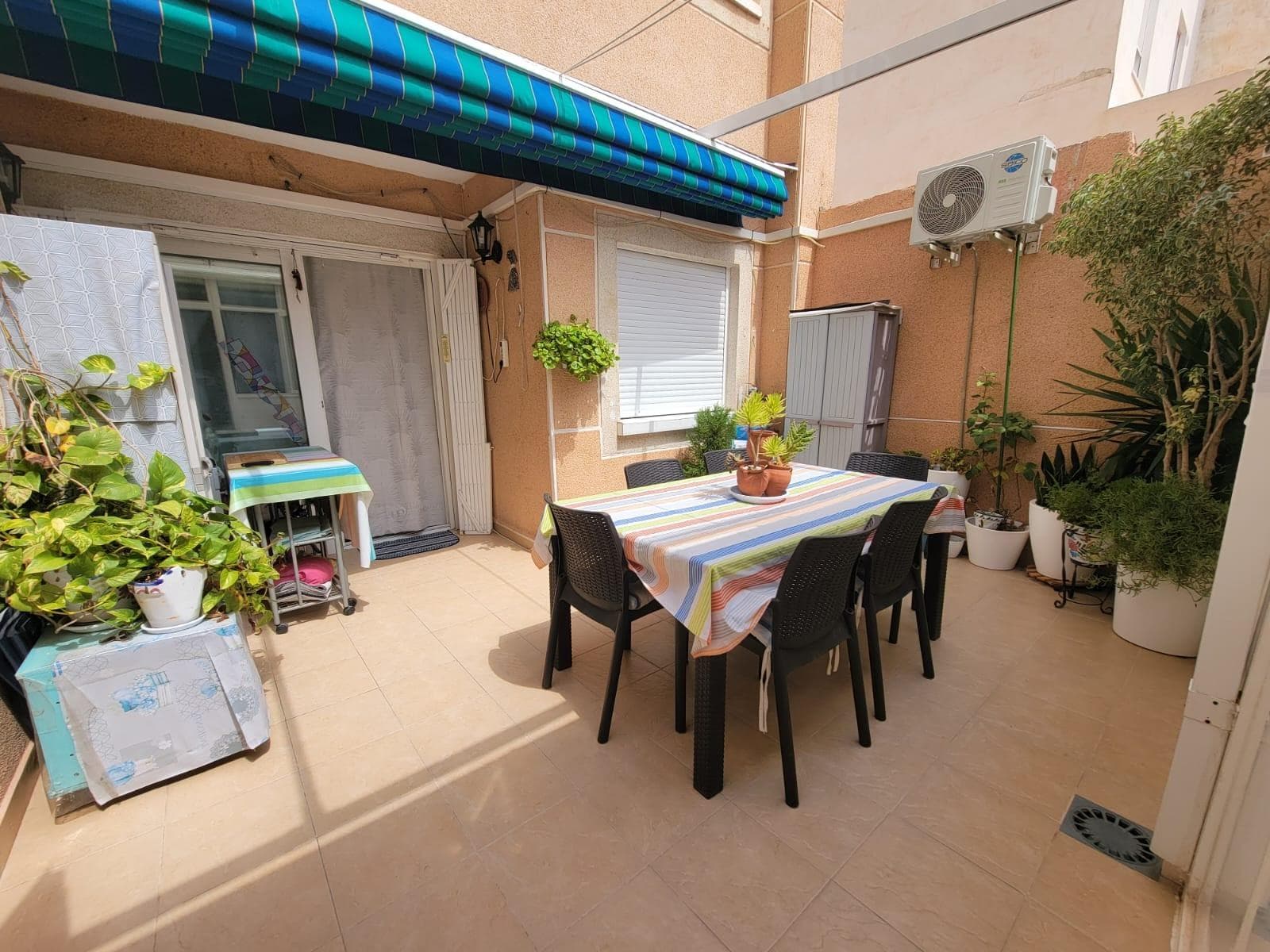 Very nice ground floor apartment, in perfect condition, just a few steps from the beach “Playa del Cura”. Optional: parking space with storage room – 17.000€ It consists of an entrance hall, a living room with access to a large terrace with a porch and awning, a fully equipped American kitchen with access to a semi-covered patio (very practical for storage), a double bedroom and a single bedroom, another extra double bedroom in the patio and a bathroom with an Italian shower. Part-furnished. Air conditioning. Access ramp for people with disabilities in the building entrance. Elevators. Perfect location, about a 3-minute walk to Playa del Cura, the Promenade and close to all amenities, restaurants, cafes, supermarkets, bus stops, and so on. Ideal for living all year round or spending holidays and enjoying the beach and the pleasant Mediterranean climate!