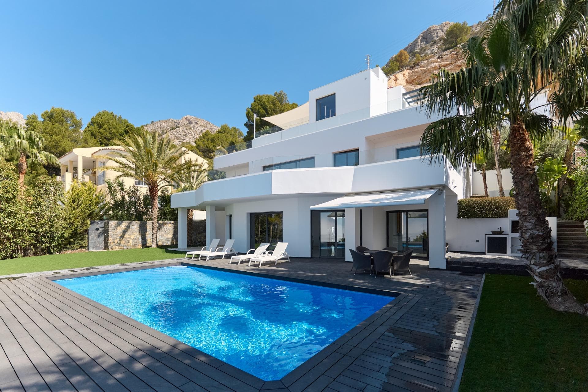 This exquisite residence, nestled in one of Costa Blanca’s most sought-after locations, blends refined design, comfort, and cutting-edge technology. Spanning three levels, one floor is dedicated to guest accommodation, ensuring privacy and ease for all residents. The villa offers 5 spacious bedrooms and 7 bathrooms, crafted with premium materials and meticulous attention to detail. Expansive windows flood the interiors with natural light and reveal breathtaking sea views. There is an open parking area for 2 cars and a closed garage for 1 vehicle, equipped with an electric car charging station. In early 2024, the property underwent a full renovation, both inside and out, with upgraded internal systems and structural enhancements to ensure optimal living conditions. High-end features include underfloor heating, central air conditioning, a smart home system, electric locks and shutters, automatic gates, solar panels, a built-in safe, an alarm system, and an internal elevator. The outdoor areas feature generous terraces, a lush garden with fruit trees, a pool with multicolor lighting, and a stylish BBQ area — all overlooking the Mediterranean.
