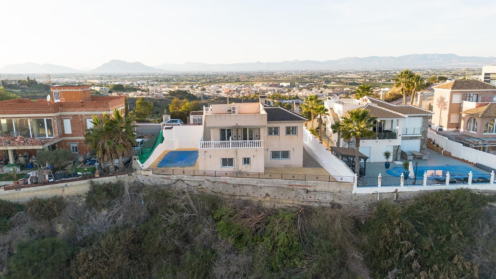 Large Villa with charm, unique views and great potential Large independent villa, located on a 500 m² plot, is the ideal project for those looking to transform a property into their perfect home. With 247 m² built distributed on two levels, the house stands out for its strategic location and its incomparable views. Villa layout: Main floor: 2 large bedrooms, 2 full bathrooms, a dressing room, separate kitchen, and a living-dining room with a fireplace that opens onto a balcony and a private solarium. Lower floor: 3 additional bedrooms and a full bathroom, perfect for guests or to personalize as you wish. The exterior, designed for enjoyment, includes: A large private pool. Space to park up to four cars. A plot that combines privacy with impressive panoramic views. The location is unbeatable, in the upper part of Ciudad Quesada, offering proximity to services and excellent connection: 10 minutes from Guardamar beach. 30 minutes from Alicante airport. Only 0.5 km from La Marquesa golf course. The villa needs some renovations but has incredible potential and is an excellent opportunity for those who value panoramic views, space, tranquility and privacy.  Rent-to-own option: For those interested in a flexible alternative, we offer the rent-to-own option under the following conditions: Down payment: 25% of the sale price.  Monthly payment: €1,700.  Contract duration: 2 years. Don't miss this opportunity and come and visit it! Taxes and expenses not included in the price.