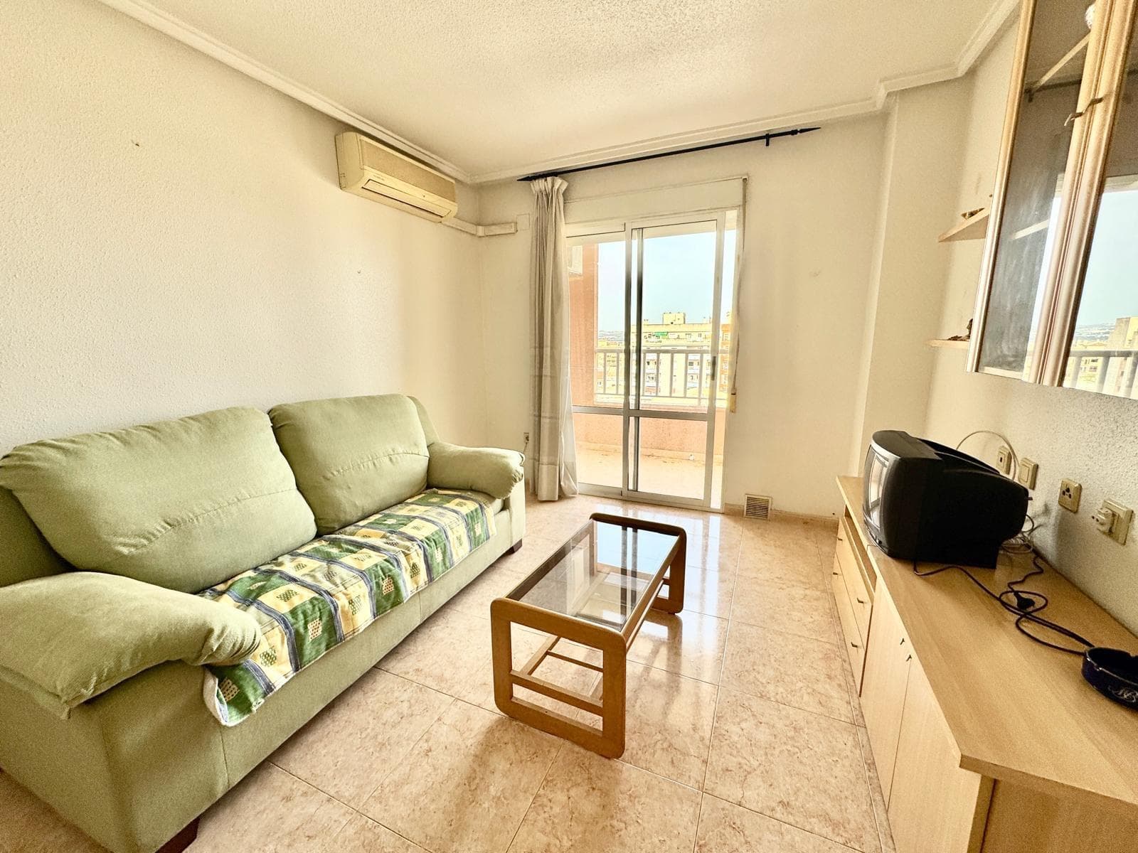 Penthouse for sale in central Torrevieja, with southwest orientation providing good natural light throughout the day. The property offers two bedrooms, one bathroom, and a living room with an open-plan kitchen, creating a comfortable and functional space for everyday living. The terrace has open views over the city and the lagoon, ideal for enjoying the outdoors. The building includes a communal pool, a practical option for summer months. The apartment is in good overall condition and is sold furnished, ready to move in. Centrally located, close to all amenities and within walking distance to the beach.
