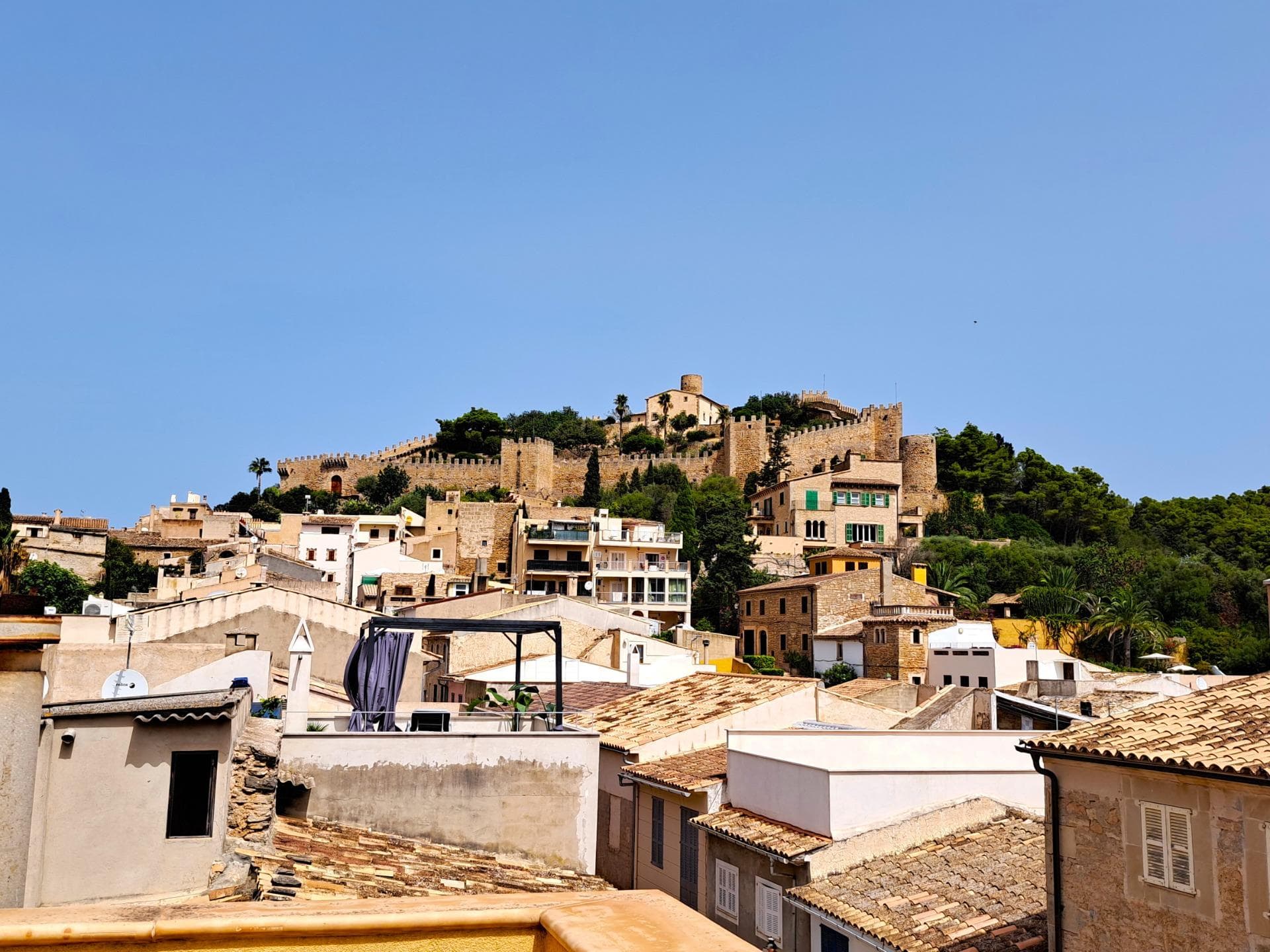 Located in the heart of Capdepera’s old town, just a few steps from Plaça L’Orient and surrounded by restaurants, bars, and all essential amenities, this magnificent recently renovated terraced house offers an unbeatable location. It combines the comfort of being in the center with privileged views of the sea, the castle, and the surrounding mountains.. The property blends Mallorcan charm with modern comfort. High-quality materials have been used throughout: wooden windows, shutters, and doors, double-glazed tilt windows, stoneware floors, and an efficient heating system with underfloor heating on the ground floor and radiators on the upper levels. Additionally, all rooms are air-conditioned. Hot water is supplied via electric boilers, and the house features a central heating system and a water softener.. The ground floor hosts the daytime living area, characterized by bright, open spaces. It includes an elegant living-dining room with an open-plan kitchen and direct access to the pool, a modern bathroom with a shower, a practical storage room, and a pantry. The kitchen has pre-installations in two possible locations, allowing the new owner to personalize the layout. From the living room, you can access the charming patio, where you’ll find the pool with a waterfall feature and an outdoor shower. There’s also a covered porch, ideal for relaxation, along with two additional rooms: a laundry area and a machine room.. The first floor is dedicated to the sleeping area, featuring two spacious bedrooms with high ceilings, built-in wardrobes, and large windows that flood the rooms with natural light. A modern bathroom with a sophisticated LED lighting system completes this level.. On the second floor, there’s a third versatile room, perfect as a study, gym, home cinema, or extra bedroom. From here, you can access a cozy private terrace overlooking the pool and Capdepera Castle, ideal for creating a chill-out area.. Finally, the property boasts a spectacular rooftop solarium offering unmatched panoramic views of the castle, the sea, and the surrounding mountains. This space is perfect for social gatherings, barbecues, relaxing afternoons, or simply enjoying the stunning scenery.. This property is ideal for those looking to combine Mallorcan charm with the comforts of a modern renovation, in a privileged location and with outdoor spaces designed for maximum enjoyment.. Note: Some images have been generated using AI technology to illustrate possible decoration ideas and showcase the property’s potential.. Important: Purchase taxes, notary fees, and registration costs are not included in the price. As a construction company, we are happy to assist you with renovations, extensions, or any type of project.