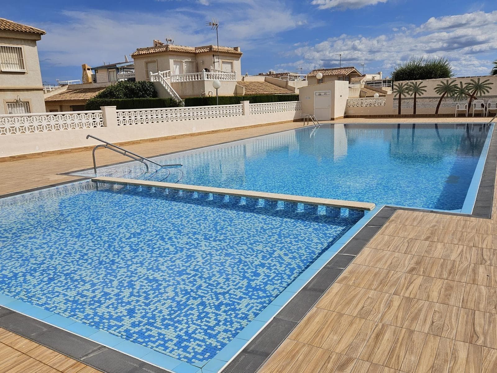 Discover this charming semi-detached villa located in the exclusive area of ​​La Zenia, Orihuela Costa. With a constructed area of ​​100 m² and a living area of ​​90 m², this property features three spacious double bedrooms that guarantee comfort for the whole family. Enjoy the Spanish sun from your spacious 30 m² private terrace or relax just steps away in the communal pool surrounded by carefully landscaped gardens. The property is located within a secure gated community, ideal for those seeking tranquility and privacy without being far from the hustle and bustle of the city. It is also close to shopping centers such as La Zenia Shopping Center, as well as local schools and hospitals, making everyday life easier. Just two kilometers from the Mediterranean Sea, you can enjoy both the coastal atmosphere and the modern amenities offered by this vibrant town. Contact us for more information.