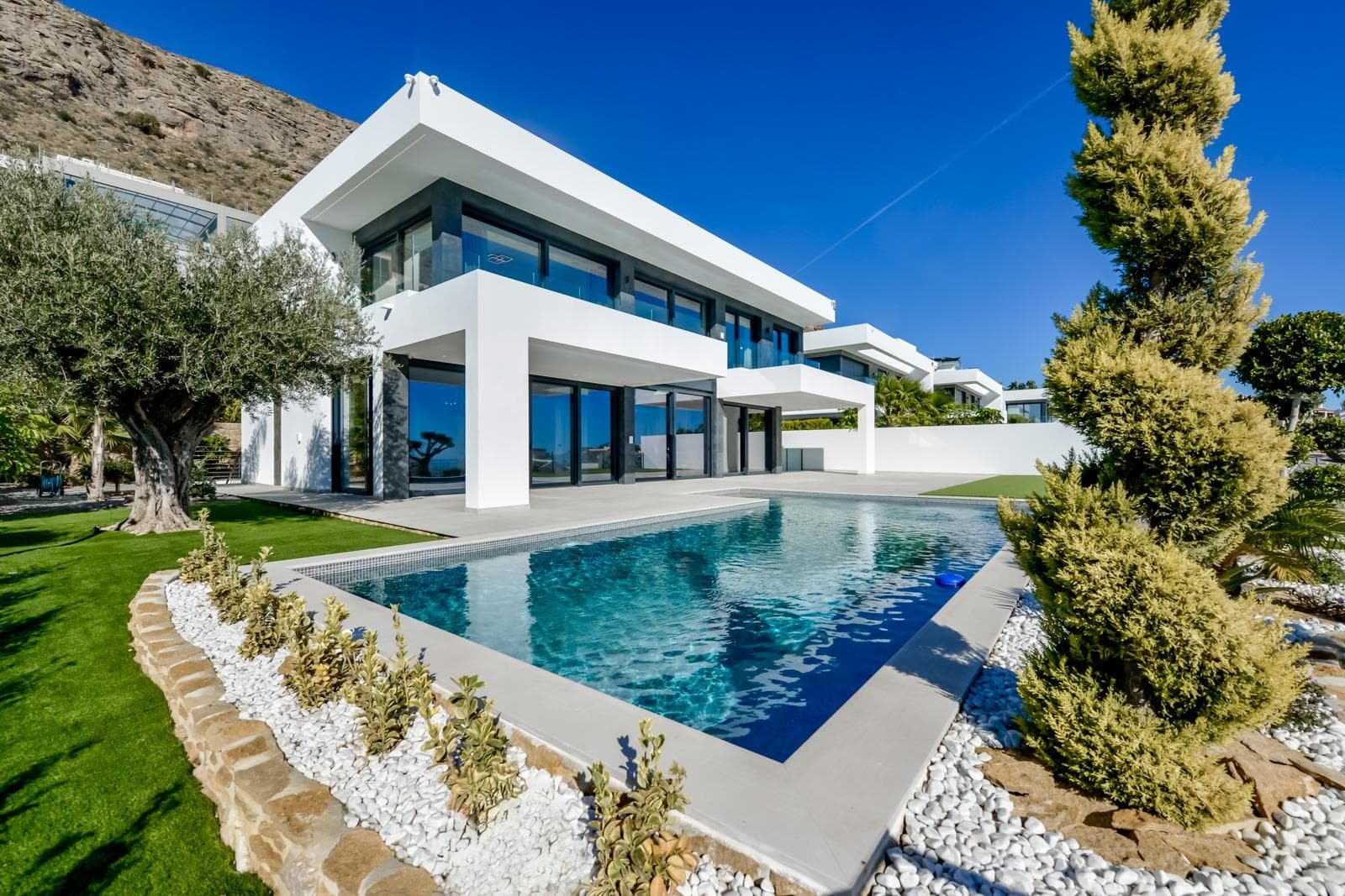 NEW BUILD LUXURY VILLA IN FINESTRAT WITH THE SEA VIEWS&#13;&#13;New Build Luxury villa with the sea views in Sierra Cortina, Finestrat.&#13;&#13;Arriving at the Urbanisation there is a natural stone wall with a height of 7 metres and the automatic access gates to the villa arriving at the covered garage at street level with double height, natural light and garden with palm trees of different heights of 180 m2, a glazed room of 78 m2 with lift, interior staircase, cloakroom and enough space to put armchairs, convert this space into an office or simply a waiting room for visitors.&#13;&#13;The next floor of 190 m2 of enclosed space is located below the plot level but 3 metres above the street level and therefore with natural light. It can be accessed by lift or staircase inside the villa, or by the staircase outside the garage, in the latter case you can only access the exterior corridors, the installations room or the main door of this floor, thus making the maintenance of the house without the need to enter inside the house. Inside this floor we will find 4 spacious bedrooms, living room with English patio of 17 m2 with the stairs to the plot, laundry, 2 bathrooms, exterior corridors of 40 m2 and installations room.&#13;&#13;When we go up to the main floor by 3 access ways we see a living room of 130 m2 with double light, open kitchen, guest toilet, panoramic sea views, and swimming pool of 54 m2 of laminate, a beautiful garden and 2 large covered terraces.&#13;&#13;To the bedrooms floor we access by lift or interior staircase where we will see a Master Bedroom of more than 50 m2 with en-suite bathroom, dressing room and terrace, two bedrooms of about 20 m2 each one, a bathroom and the terrace for these bedrooms.&#13;&#13;Villa is equipped with Led exterior and interior, underfloor heating, domotics, high Gamma crystals, centralized air conditioning, automatic blinds, high ceilings and much more:&#13;Living room- 95 m2&#13;Bedrooms- 8 (main 52 m2 and secondary 20 m2)&#13;Bathrooms- 5&#13;Plot- 890 м2&#13;Built- 998 м2&#13;Swimming pool- 12 X 5&#13;Four Floors&#13;Garden (20 m2) - fully finished with automatic irrigation system&#13;Lift (Otis) inside the house&#13;Underfloor heating&#13;Domotics (control of air conditioning, underfloor heating, interior and exterior lighting, blinds)&#13;Electric blinds&#13;Exterior and interior lights brand name Siemens&#13;High ceilings up to 3,20 m high&#13;Impressive sea view&#13;One floor for guests&#13;Aerothermal heating&#13;Fully fitted kitchen with island&#13;Fitted wardrobes&#13;Porcelain tiled floor &#13;Wall with natural stone hand carved&#13;Garage for 4 vehicles with automatic doors 160 m2 + entrance hall 78 m2&#13;Open parking 37&#13;&#13;Villa located in the Sierra Cortina resort complex, ​next to two golf courses, theme parks, a large shopping centre and a few minutes from the beaches of Benidorm.&#13;&#13;Finestrat located in the Marina Baixa region of the Costa Blanca, close to neighbouring Benidorm and about 40 kilometres from the city of Alicante and the international airport.&#13;&#13;The village is situated on the mountainside of Puig Campana and offers beautiful views of the mountains, the coast and the Mediterranean Sea.&#13;