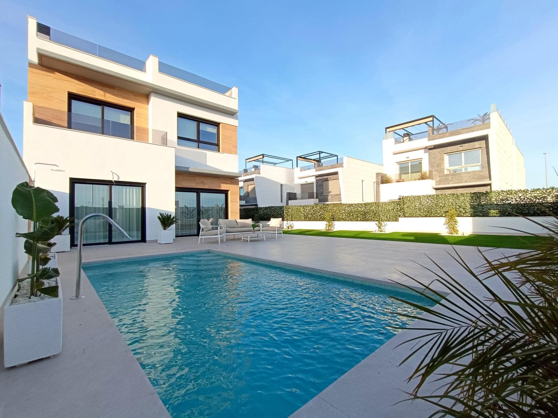 Luxury New Build Semi-Detached Villas in Benijófar, Costa Blanca&#13;&#13;Prime Location in Benijófar with Convenient Access to Amenities&#13;&#13;Discover a new level of luxury living in the charming town of Benijófar, a highly sought-after area on Spain’s Costa Blanca. These newly built semi-detached villas are situated in a vibrant neighborhood with a perfect blend of modernity and local charm, offering easy access to all essential services and attractions. Just 10 km from the golden beaches of Guardamar del Segura and 30 km from Alicante Airport, the villas are strategically positioned for convenience and lifestyle.&#13;&#13;Spacious and Modern Design with Premium Finishes&#13;&#13;Each villa is designed with a contemporary aesthetic, featuring clean lines and high-quality finishes. The layout includes three spacious bedrooms and three bathrooms, providing ample space for families or guests. The open-plan living-dining area seamlessly connects to a fully equipped kitchen, offering a perfect space for entertainment and family gatherings. Large windows allow plenty of natural light, creating a bright and welcoming atmosphere throughout the home.&#13;&#13;Private Outdoor Spaces with Pool and Solarium&#13;&#13;These villas include private outdoor spaces designed for relaxation and enjoyment of the Mediterranean climate. The tiled garden features a 2.5x5m swimming pool, perfect for cooling off on warm days, and ample parking space. The properties also come with a rooftop solarium, where you can enjoy views of the surrounding area. The solarium is equipped for a potential jacuzzi installation, making it a perfect spot to unwind and enjoy the sunset.&#13;&#13;High-Quality Inclusions for Ultimate Comfort&#13;&#13;Every villa comes fully equipped with top-of-the-line appliances, including a panelled fridge freezer, induction hob, panelled dishwasher, built-in microwave, and oven. Additional features include air conditioning units for climate control, underfloor heating in the bathrooms, and electric shutters for privacy. Spotlights and outdoor wall lights enhance the ambiance, making each villa both functional and luxurious.&#13;&#13;Benijófar: A Blend of Tradition and Modern Living&#13;&#13;Benijófar is a charming village with a welcoming atmosphere, known for its beautiful church, local shops, supermarkets, pharmacies, banks, and delightful restaurants. Nature lovers will appreciate the nearby natural park, ideal for walking and exploring. Golf enthusiasts will find several golf courses within a short drive, while families can enjoy nearby water parks in Rojales (4 km) and Torrevieja (12 km). The villas are also well-connected, with the N-332 and AP-7 highways providing easy access to surrounding towns.&#13;&#13;Ready to Make Benijófar Your New Home?&#13;&#13;Embrace the luxury and convenience of these modern villas in Benijófar. Don’t miss this opportunity to enjoy life on the Costa Blanca. Contact us today to arrange a viewing and take the first step toward your dream home.&#13;