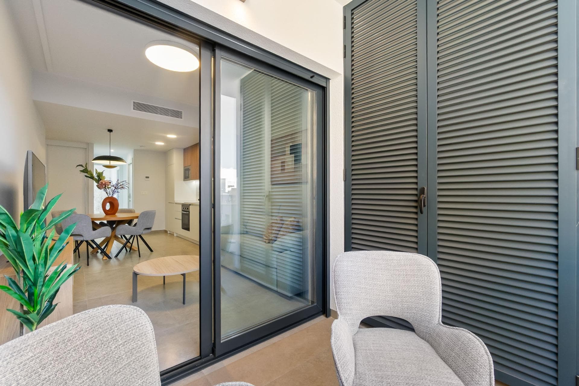 This modern resale apartment offers a functional and bright layout in a convenient area of Torrevieja. It consists of two bedrooms, including the main one, and two bathrooms equipped with glass shower screens and wall-mounted sinks; one finished with textured white tiles and the other with a wood-effect design. The bedrooms have a simple, minimalist style, with windows that provide good natural light. One bedroom includes a decorative wall as part of the interior finish. The open-plan living area includes a lounge, TV unit and floor-to-ceiling sliding glass doors leading to the balcony. The interior features a neutral palette and light ceramic flooring. The layout is designed for practical use of space. The building offers a communal swimming pool and a rooftop solarium with views towards the sea. The location provides easy access to services and is approximately a 4-minute walk from Playa del Cura, the promenade and the town centre. The apartment is sold with the furniture and equipment shown in the photos, ready to move into. Call us to arrange a viewing.