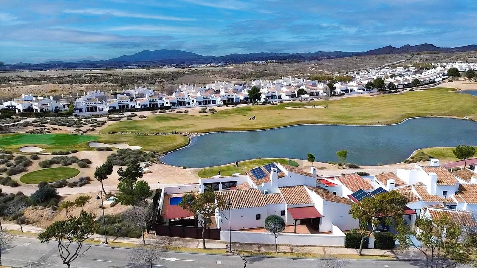 Welcome to the home of your dreams! This is a rustic Mediterranean-style villa on one of the most luxurious golf courses in the southeast of Spain. A home that radiates warmth and comfort in every corner! This fantastic villa, built with love and care by one of the most well-known construction companies in the area, offers an unrivalled living experience. From the moment you cross the threshold, you will feel the magic of a home where every detail has been carefully thought out to create a welcoming and familiar atmosphere. Natural light floods every room thanks to its corner location and exterior design. The spacious living room, with its fireplace that promises warm winter evenings, becomes the heart of the home. With ceilings up to six metres high, which provide an unparalleled feeling of spaciousness and relaxation. The independent kitchen, with access to an outdoor patio and equipped with a large pantry, provides light and freshness, inviting you to create delicious recipes and share unforgettable moments. The villa is distributed all on one level at street level without stairs or architectural barriers. This home has five large bedrooms that offer the rest and privacy that your family deserves. The master bedroom, with its own dressing room and bathroom, is an oasis of tranquility. An additional toilet guarantees the comfort of everyone. But the magic does not end here. A space like an open-plan games room with direct access to the pool area invites you to unleash your imagination. A personal gym? A home cinema to enjoy movie nights with friends? The possibilities are endless. Next to this games room, there is one of the bedrooms with its own bathroom, truly, a corner to enjoy. This home is equipped with 22 solar panels, which make the house energy self-sufficient for most of the year. The garden area, which is on the front line of the golf course, has very nice views of one of the holes and a pond, a place that encourages you to enjoy the tranquility and have fun with friends. In the garden, we can find a large swimming pool that will undoubtedly refresh your summer days. Next to the pool, we have a gazebo with an Argentine barbecue, which will undoubtedly be the center of attention with visits and meals with family and friends. In the front of the house we have a private and covered parking area to be able to put the vehicles. This villa is much more than a house, it is a home where memories are created and dreams come true. Every corner tells a story, every space invites coexistence. At the Valle Golf Resort, it is a private resort with security which has all the services at your fingertips, a beautiful social club with a restaurant. The Valle Golf Resort is the perfect place to establish your home. Its proximity to Cartagena, Murcia and the airports connects you to the world without giving up the tranquility of a privileged environment. Don't miss this unique opportunity to live in the home you've always wanted! * The indicated RRP does not include taxes or deed fees. * The surfaces expressed on this page are descriptive and approximate, so they have no contractual or binding value. Prices may be subject to change without prior notice.