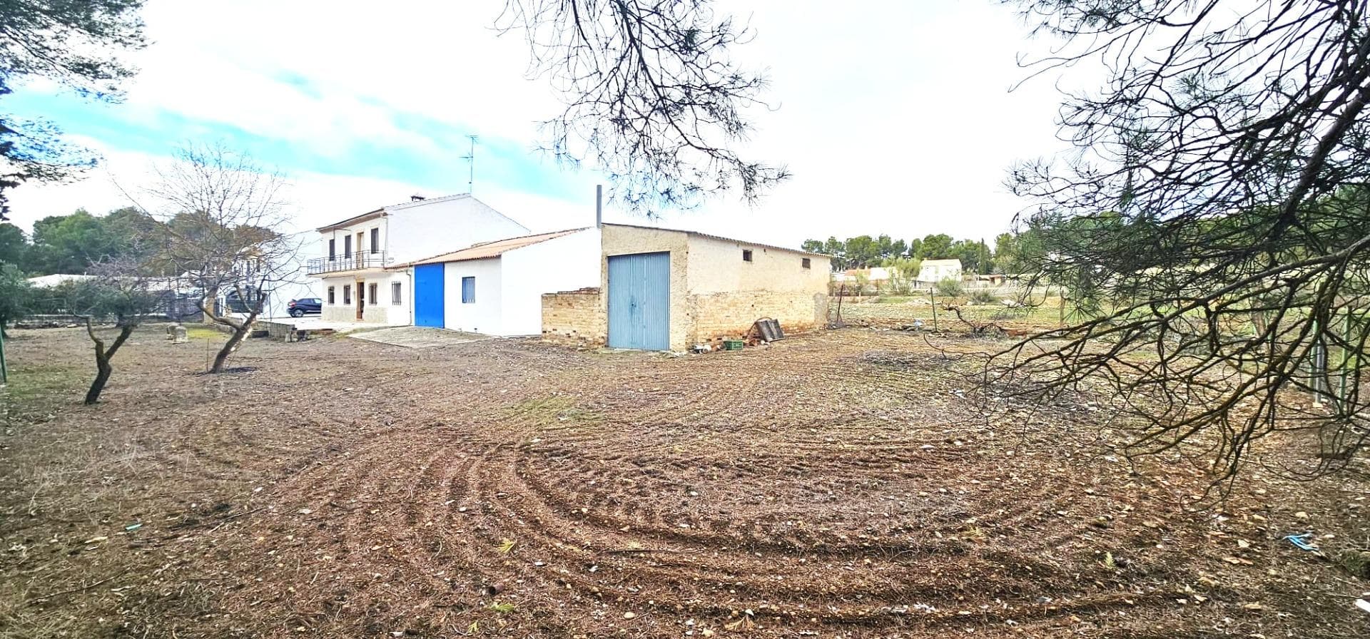 Exclusive property located on the waterfront of the Bermejales Reservoir, with unobstructed views of the reservoir and the surrounding natural landscape. This unique property combines a strategic location, a large plot of land, and a spacious building, making it an excellent opportunity for developing a rural guesthouse with complementary services. The house sits on a plot of over 3,300 m², perfectly suited for creating outdoor areas for tourist use, such as a swimming pool, sports areas, or landscaped common spaces. Furthermore, its shape and size allow for the creation of a caravan park with a capacity for approximately 30 caravans, an increasingly popular service in these types of natural settings. Property Layout and Use The main building features: Seven bedrooms, ideal for use as individual rooms. Separate kitchen with dining area and fireplace, easily adaptable as a communal kitchen or basic restaurant space. Large, bright main living room, ideal as a reception area or relaxation space. Second large common room with fireplace, perfect as a social room, communal dining room, or activity area. Two bathrooms, separate laundry room, and enclosed garage. The layout allows for easy adaptation for hospitality use, while maintaining spacious common areas and a comfortable experience for guests. Preliminary Economic Study (non-contractual) Hostel Operation: 7 rooms Estimated average price: €60/night per room Potential daily income: 7 × €60 = €420/day Caravan Parking: Approximate capacity: 30 caravans Estimated price: €12/day per unit Potential daily income: 30 × €12 = €360/day Estimated combined gross daily income: €420 + €360 = €780/day This proposal positions the property as a very attractive tourism investment opportunity, especially during shoulder and peak seasons, with the possibility of expanding services (swimming pool, restaurant, sports or nature activities) and further improving profitability. Conclusion: A property with enormous economic potential, located in a privileged natural setting, with direct views of the reservoir and the capacity to cater to both traditional tourism and the growing caravan tourism sector. Ideal for investors looking for a solid, versatile project with multiple avenues of exploitation in one of the most valued natural enclaves in the province of Granada.