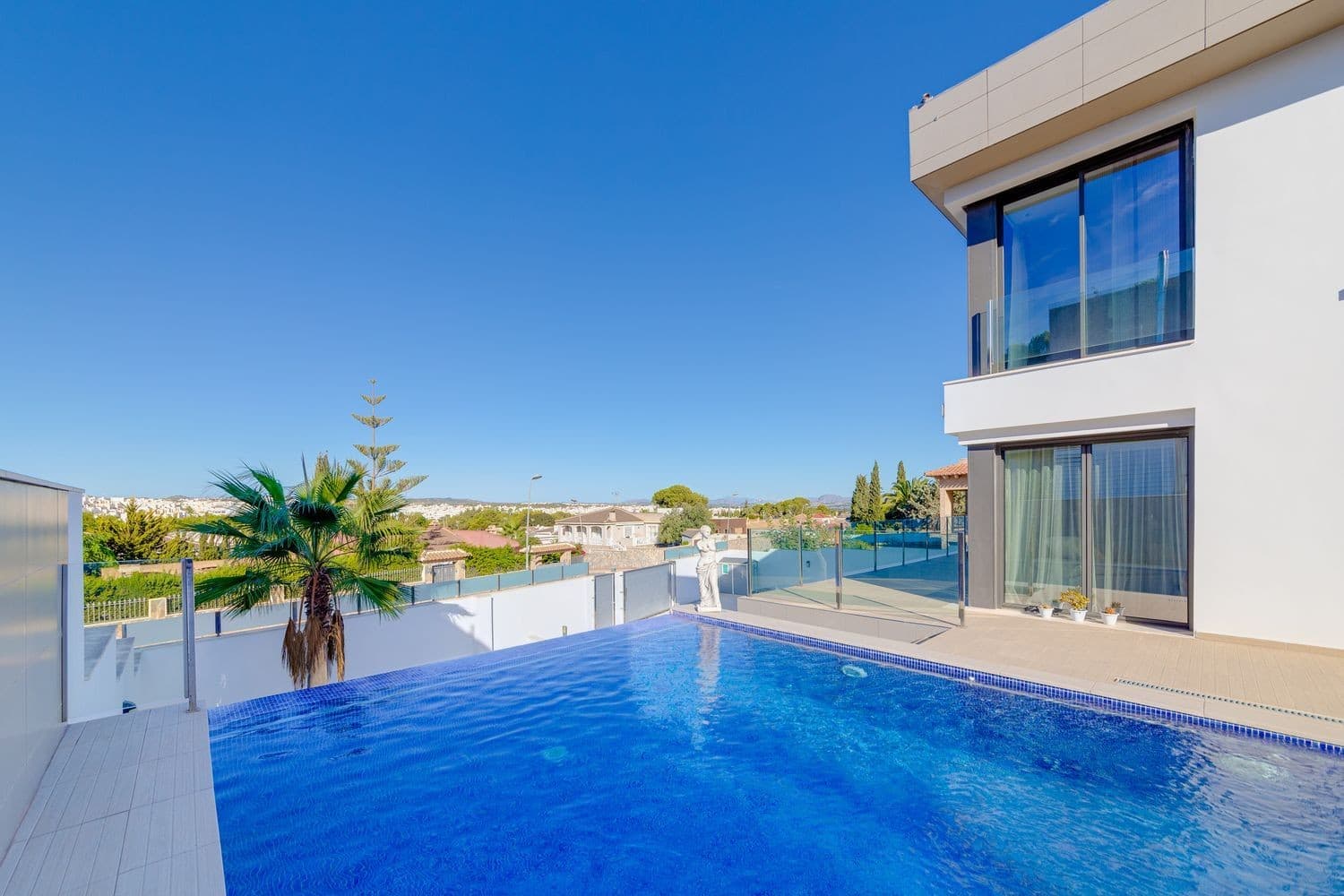Welcome to this exceptional detached villa, built in 2018 on an 806 m² plot, combining contemporary design, comfort and high-level security. 393 m² built area – 3/4 bedrooms – 4 bathrooms Infinity pool with waterfall & spectacular views Two independent entrances (including parking for 5 cars + closed garage) Bright living room with designer fireplace & high-end kitchen Master suite with 23 m² private terrace Basement with gym, laundry room and machine room Underfloor heating, solar panels, & A energy certification Enhanced security (interior & perimeter cameras, earthquake-resistant structure) Exteriors designed to enjoy Mediterranean living: spacious terraces, garden and absolute comfort all year round. Sold fully furnished and equipped, ready to move into. Located in an exclusive residential setting, this villa is a haven of luxury and elegance on the Costa Blanca. Contact us today to schedule your visit and discover this unique gem.