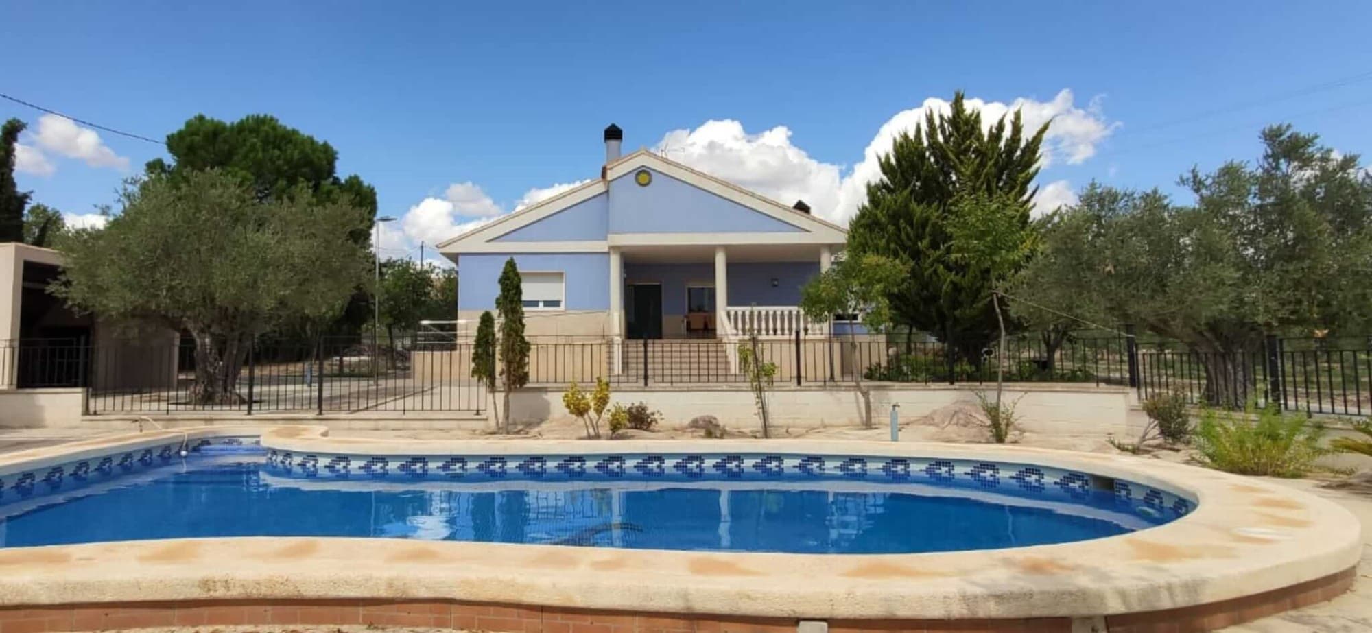 This beautiful detached villa located in a quiet neighbourhood, close to the centre of Yecla is equipped with all conveniences. 

You enter the fully fenced plot through a beautiful electrically controlled gate over a paved driveway and park your car under the carport, where there is space for no less than 4 cars.

In front of you is the beautiful swimming pool with jacuzzi and a terrace to soak up the sun. Next to it is the outdoor kitchen, for making delicious paella or barbecuing. 

There is a covered terrace with sun/wind screens, so you can sit outside all year round, this terrace can be reached via stairs or a ramp, ideal for when you want to go inside with a pram or wheelchair.

Inside, on the left you will find the 18.5m2 dining kitchen with electric hob, oven and dishwasher. There are also 2 large fridge-freezer combinations. Adjacent to the kitchen is a laundry room/utility room with sink, washing machine and storage space. To the right, you will find the spacious cosy living room with fireplace, which can be used to heat the whole house! There is also oil-fired central heating and hot-cold air conditioning. On the ground floor you will also find 4 bedrooms (13.7m2, 14.1m2, 16.4m2 and 19.8m2) and 2 bathrooms (5.1m2 and 6.6m2). All windows are double-glazed with tilt-and-turn windows, fitted with mosquito nets and shutters, and you can enjoy views of the garden and/or swimming pool from all rooms.

Via the stairs, with a large built-in cupboard for storage underneath, you reach the insulated attic room (through roof insulation) of no less than 23.7m2, here is also room for a toilet. From the attic room, you reach the roof terrace through French doors from where you can see the beautiful green surroundings and even the mountains!Under the house is a semi-basement/crawl space which ensures you don't suffer from rising damp, in addition there is plenty of storage space. Besides the aforementioned roof insulation and double glazing, the house also has cavity walls, this ensures a pleasant temperature all year round.If you are on holiday and therefore not at home, don't worry as there is also an alarm system with sensors, which you can control through an app, so no monthly subscription fee! The house is sold partly furnished (including the wardrobe and beds).
