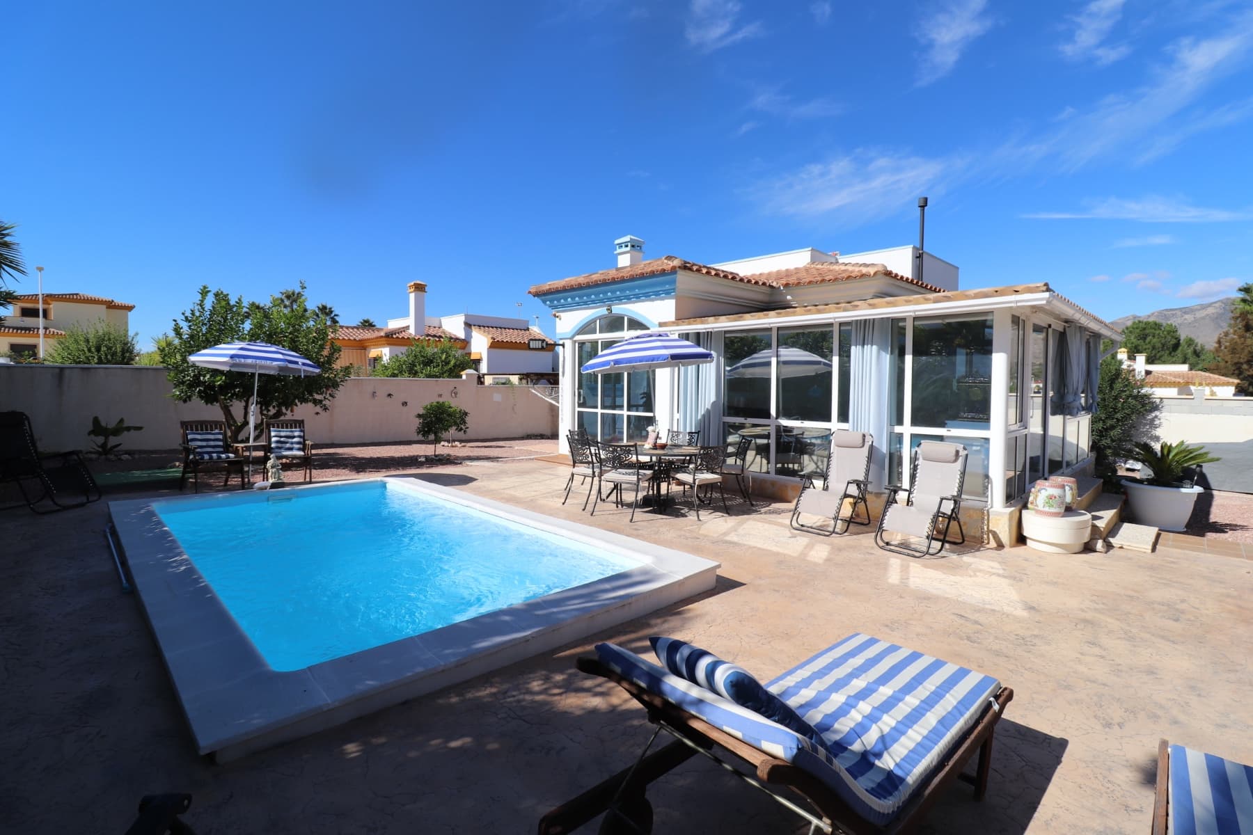 This beautiful villa in perfect condition is located in a very quiet residential area between the two villages of Hondon, with all amenities nearby. It comprises a spacious veranda overlooking the pool and garden, a living room with open-plan kitchen, two bedrooms and two bathrooms. A solarium offers superb views of the surrounding mountains. The garden has been carefully landscaped and features a swimming pool, several shaded terraces, a summer kitchen, parking for 2 cars, a garden shed and numerous flowers and fruit trees. The house will be sold fully furnished except for the television, garden furniture and water dispenser. 35 minutes from Alicante airport and the beaches.