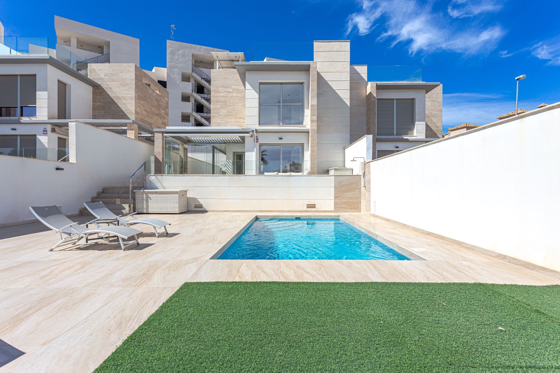 Modern villa for sale in Villamartin, Orihuela Costa, built in 2019, featuring 4 bedrooms, 3 bathrooms, private pool, solarium, and solar panels. With 150 m² of living space on a 320 m² plot, this property offers a spacious and elegant layout across three levels. The ground floor includes a bedroom and a bathroom with walk-in shower; upstairs you’ll find two more bedrooms, another bathroom, and access to a sunny terrace and private solarium. The basement adds extra versatility with a fourth bedroom, a third bathroom, and a generous living area.This south-facing villa comes almost fully furnished and includes a bioclimatic terrace, private parking, and a large outdoor area perfect for relaxing or entertaining. Energy-efficient thanks to solar panels, a battery system, and an EV charger, this is an ideal eco-friendly home.Located close to golf courses, beaches, international schools, and all amenities, it’s perfect as a permanent residence, holiday home, or investment property in Costa Blanca. Don’t miss this opportunity—contact us today to arrange a viewing!