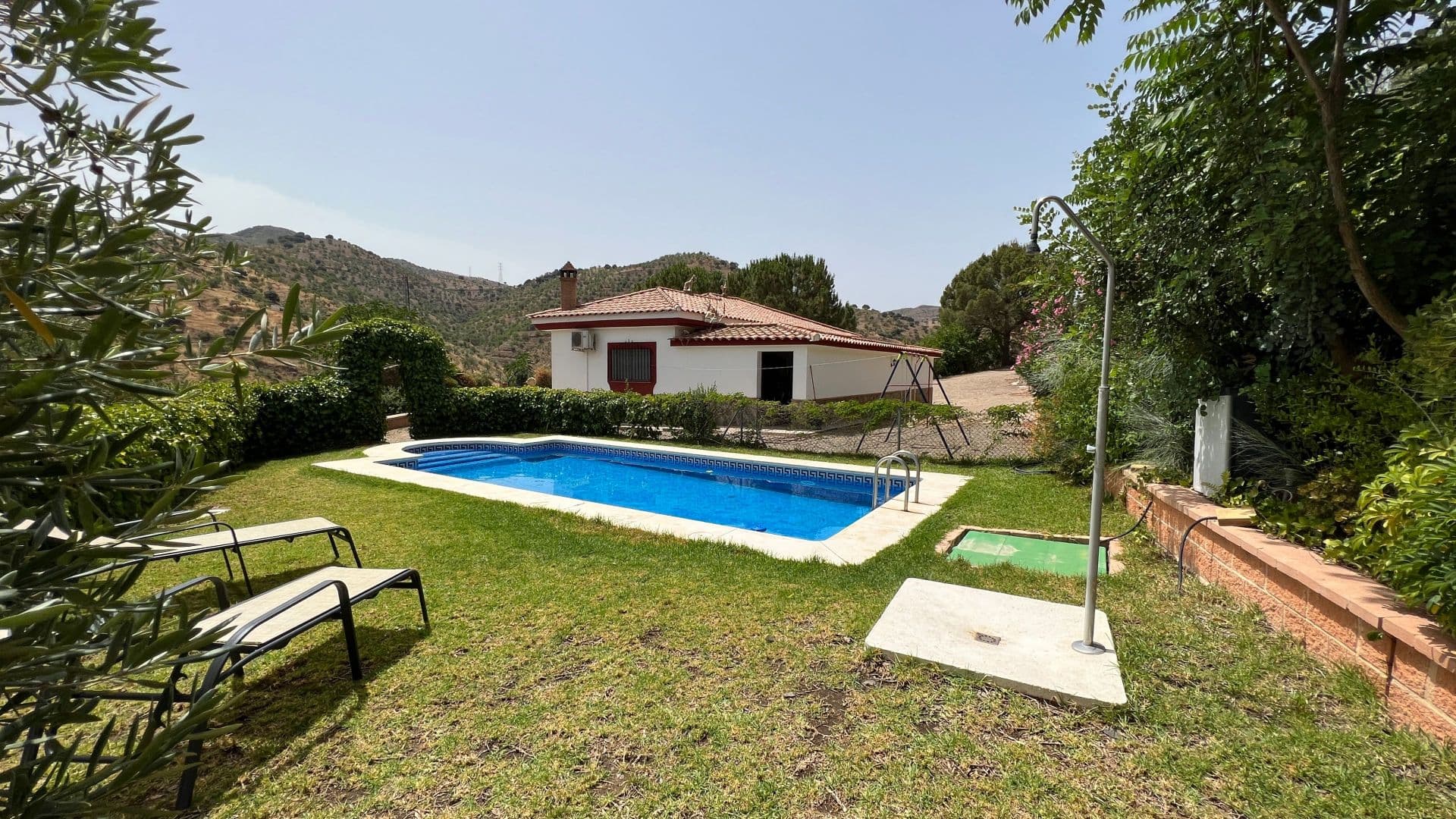 If you are a nature lover, and you are looking for peace and tranquillity, then this house is definitely for you! Magnificent single storey country house, in the middle of hundreds of olive trees, comprising 3 bedrooms, a large bathroom with Italian shower, completely fitted open-plan kitchen with dining area, living room with fireplace, and a storeroom. From the kitchen you can access a covered terrace, perfect for enjoying your morning coffee, and at the back of the kitchen there is a large patio where you can enjoy the afternoon shade, and a garage with utility room. To the side of the property is lovely a green area with a large swimming pool, from where you will only hear the birds singing. PLEASE NOTE: The access to this house is not easy. There is 11km of mountain road from Estación de Cártama to the “Ermita de las Tres Cruces”, then 5km (about 15 minutes) of dirt track. Once there, this house is a little paradise where you can disconnect from the hectic life of the city.