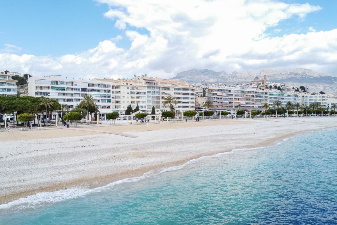 Beachfront Apartment with Spectacular Sea Views in AlteaStep into Mediterranean luxury with this stunning, recently renovated 88 m² beachfront apartment in the heart of Altea’s Playa de la Roda. Boasting breathtaking panoramic sea views stretching to Calpe, the port of Altea, and the Sierra Helada, this spacious and bright home is ready for you to move in and enjoy.Located on the first floor of a well-maintained building with a lift, the apartment features:2 spacious bedrooms with built-in wardrobes, one with an en-suite bathroom and the other with direct terrace access2 modern bathrooms, both with walk-in showersBright and airy living-dining area with floor-to-ceiling sliding windows opening onto a large covered terrace with unbeatable sea viewsFully equipped open-plan kitchen with top-of-the-line Miele appliancesHigh ceilings throughout, offering a sense of space and allowing for the possibility of adding bunk beds or loft storageUtility/laundry room and multiple cleverly integrated storage solutionsAir conditioning (hot/cold) for year-round comfortEnjoy waking up to the sunrise over the sea from your master bedroom, and entertain guests while taking in the peaceful sound of the waves from your terrace.Prime LocationSituated directly on the beachfront, the apartment offers immediate access to Altea’s picturesque promenade with its vibrant selection of cafés, restaurants, shops, and local amenities including public transport, pharmacies, and more.A leisurely stroll will take you to the iconic old town of Altea, known for its whitewashed houses, blue-domed church, and cobbled streets. Or walk along the coast to reach Albir and Benidorm via the scenic Sierra Helada Natural Park.A Rare OpportunityWhether you’re looking for a stylish seaside home or a high-return investment property, this is a rare opportunity to own a frontline apartment in one of Costa Blanca’s most sought-after locations.Contact us today to schedule a viewing!