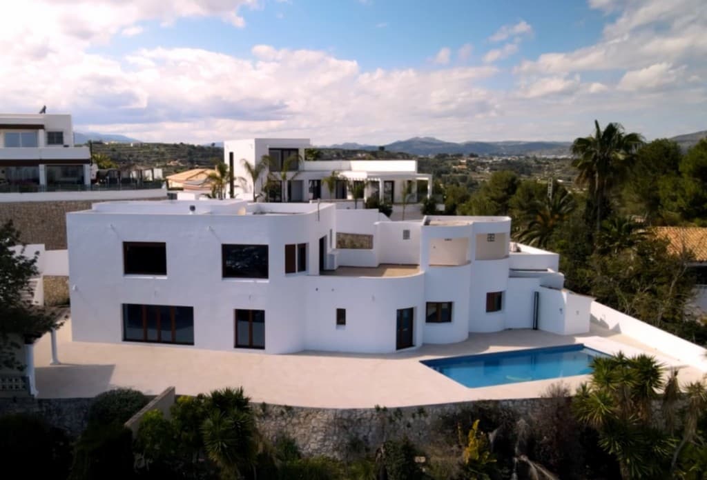 Modern Villa with 5 Bedrooms, Private Pool, and Panoramic Views in Teulada-MorairaThis villa is located in a quiet residential area, just minutes from the coastal town of Moraira — offering complete privacy, stunning views, and close proximity to beaches, restaurants, and amenities.Welcome to this elegant and spacious villa, just a short drive from the beaches, town center, and marina of Moraira. The property sits on an elevated plot, providing breathtaking views over the valley.The villa features modern finishes and generous indoor and outdoor living areas:Spacious open-plan living and dining room with large sliding doors opening onto the terrace5 bedrooms and 4 bathrooms, including a luxurious en-suite with freestanding bathtub and direct access to a large terrace with panoramic viewsModern bathrooms with unique tile finishes and walk-in showersPrivate swimming pool, perfect for enjoying the sun and total relaxationMultiple terraces and covered outdoor spaces, ideal for lounging, al fresco dining, or creating a summer outdoor kitchenLarge windows throughout the home offer abundant natural light and stunning views of the surrounding hillsTwo separate driveways, each with its own automatic gate – for comfort and private accessHigh-end finishes including slate flooring, recessed lighting, and designer fixturesLocated in Teulada, this villa offers a peaceful and residential atmosphere just a short distance from the vibrant coastal town of Moraira. A perfect balance between tranquility and convenience, with supermarkets, restaurants, schools, golf courses, and beaches just minutes away.