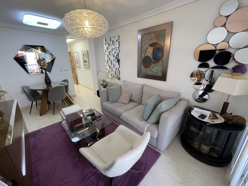 Immaculate 2-Bedroom Apartment with Terrace in Torrevieja CenterThis elegant and move-in-ready apartment is located in the prestigious Edificio Larrosa II on one of the quietest streets in central Torrevieja. Fully furnished and tastefully decorated, it offers the perfect combination of comfort, style and convenience, whether for permanent living, holiday use or as a rental investment. Its prime location places you within walking distance of the beaches, Parque de las Naciones, and all essential amenities.The apartment welcomes you with a bright and sophisticated living and dining area, designed with modern décor, a plush sofa, a designer light fixture and a warm atmosphere that flows seamlessly to the private terrace. The terrace, accessed through large glass doors, is an inviting space to enjoy coffee or relax outdoors. A fully separate kitchen is equipped with wooden cabinetry, granite countertops, tiled backsplash, quality appliances and a large window that ensures excellent ventilation and natural light.There are two spacious bedrooms, each designed with comfort in mind. The master bedroom features a large bed, stylish furniture, a mirrored wardrobe, TV and soft natural lighting. The second bedroom is equally welcoming, furnished with a bed, nightstands and another mirrored wardrobe, making it ideal for children or guests. The bathroom is bright and functional, with a corner shower, vanity, WC, bidet and a window for fresh air.The building itself is well maintained, with polished marble corridors, two elevators, a secure entry system and a clean mailroom. On-street parking is available just outside. With its central yet peaceful location, this apartment offers year-round comfort, easy walkable access to all services and beaches, and excellent rental potential. It is a turnkey property that combines lifestyle and investment in one of Torrevieja’s most desirable addresses.