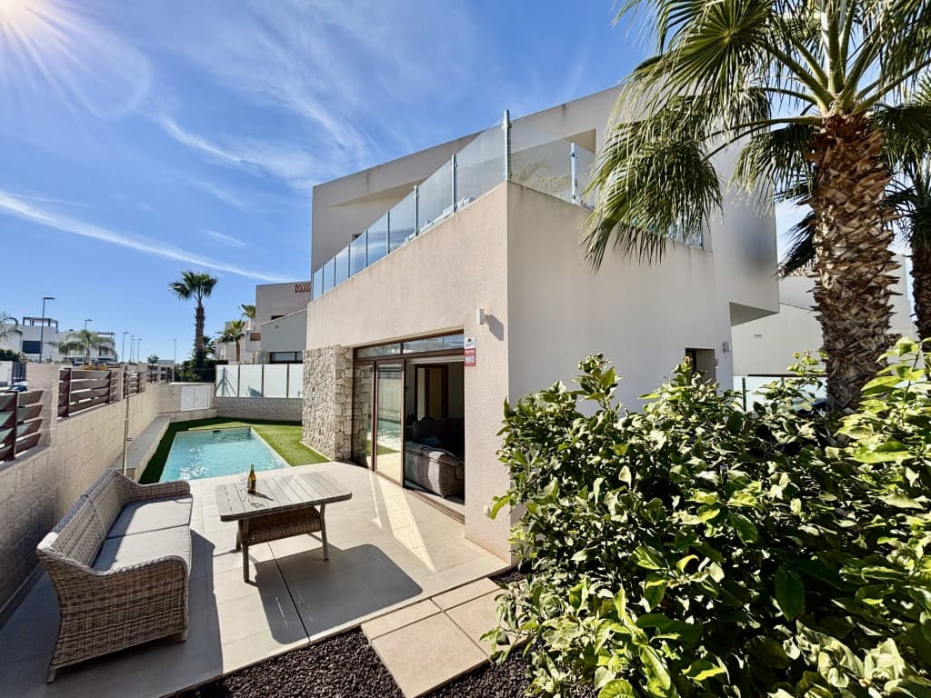 Unique Architect-Designed Villa on a Prime Corner. This almost-new, architect-designed detached villa in the charming town of Benijófar presents a rare opportunity to own a truly distinctive property. Originally built as a show home and ideally positioned on a sought-after corner plot, the villa perfectly combines contemporary architecture, high-end finishes and a thoughtfully designed layout, making it one of the most exceptional homes in the area.From the moment you arrive, the villa impresses with its striking modern design and clean architectural lines. The property is surrounded by beautifully landscaped, low-maintenance gardens that offer year-round appeal with minimal upkeep. A generous private parking area provides both convenience and privacy, while the overall layout enhances the sense of space and comfort.Inside, you are welcomed into a bright and open-plan living area where the kitchen, dining space and lounge flow seamlessly together. Floor-to-ceiling windows flood the interior with natural light and provide stunning views of the terrace, garden and private swimming pool. The sleek, fully fitted kitchen features high-quality appliances and contemporary cabinetry, complemented by a separate utility room for added practicality. A guest toilet is conveniently located on this level.The ground floor also hosts a spacious double bedroom with an en-suite bathroom and direct access to the pool area, making it ideal for guests or as a luxurious ground-floor master suite. The private swimming pool is a true highlight, offering a tranquil space to relax, entertain or simply enjoy the Mediterranean sunshine.Upstairs, you will find two further generous double bedrooms, each with its own en-suite bathroom and finished to a high standard with comfort and style in mind. Both rooms benefit from ample space and elegant details, creating peaceful retreats for rest and relaxation. This level also features a large terrace with open views of the surrounding area—perfect for morning coffee, evening drinks or soaking up the serene atmosphere.More than just a home, this villa is a showcase of refined design and lifestyle living. As a former show home, it includes bespoke features and premium materials rarely found in standard properties, with every detail carefully considered to maximise both aesthetics and functionality.Located in Benijófar, one of the most desirable villages on the Costa Blanca, the villa enjoys close proximity to local amenities including shops, supermarkets, restaurants, markets and scenic walking routes. The beautiful beaches are just a short drive away, and excellent road connections together with easy access to Alicante International Airport make travel effortless.Whether you are seeking a permanent residence, a stylish holiday home or a smart investment, this architect-designed villa offers outstanding value in a prime location. The combination of unique design, luxury features and a practical layout makes this a truly exceptional opportunity. Early viewing is highly recommended, as properties of this calibre are rarely available.