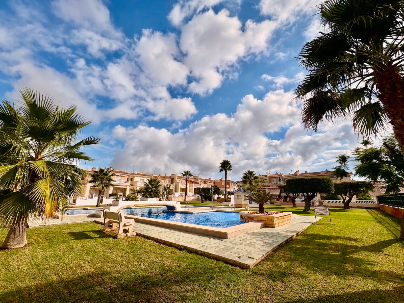 We present a unique opportunity to acquire a magnificent "Lola" model duplex, located in the exclusive Residencial Fortuna, within the prestigious Doña Pepa urbanization in Ciudad Quesada (Rojales). This charming corner duplex combines comfort, style, and a prime location in a peaceful, family-friendly environment.The property boasts a built area of 101 m² and a generous 90 m² private garden, perfect for enjoying outdoor activities, hosting gatherings, or relaxing under the Mediterranean sun. Its functional design includes three bedrooms and two bathrooms, ideal for families or those seeking extra space. The independent kitchen, fully equipped, opens to a cozy rear porch, perfect for soaking up the afternoon sun. The bright and spacious living-dining room connects to a front porch, where you can enjoy the morning sunshine.Additionally, the property features a practical covered carport, with ample space for parking a car and storing bicycles, ensuring convenience and security. The home is delivered fully furnished and equipped with appliances and air conditioning, ready to move in from day one.One of the standout features of Residencial Fortuna is its stunning communal swimming pool, considered one of the largest and most beautiful in Doña Pepa, perfect for refreshing swims and enjoying leisure time in a well-maintained, exclusive setting.Advantages of Living in Doña Pepa UrbanizationDoña Pepa is one of the most sought-after areas in Ciudad Quesada, renowned for its tranquil, elegant, and well-planned environment. This urbanization offers the perfect blend of serenity and proximity to essential services: supermarkets, restaurants, pharmacies, medical centers, and leisure areas are just a short walk away. Furthermore, its excellent location allows you to reach the beaches of Guardamar, La Marquesa golf course, and the cities of Alicante and Torrevieja in just a few minutes by car. Doña Pepa is ideal for those seeking a permanent residence or a holiday home in an area with high demand and great potential for appreciation.This property is an exceptional opportunity to enjoy Mediterranean quality of life in a home designed for comfort and enjoyment. Contact us for more information or to arrange a no-obligation viewing!