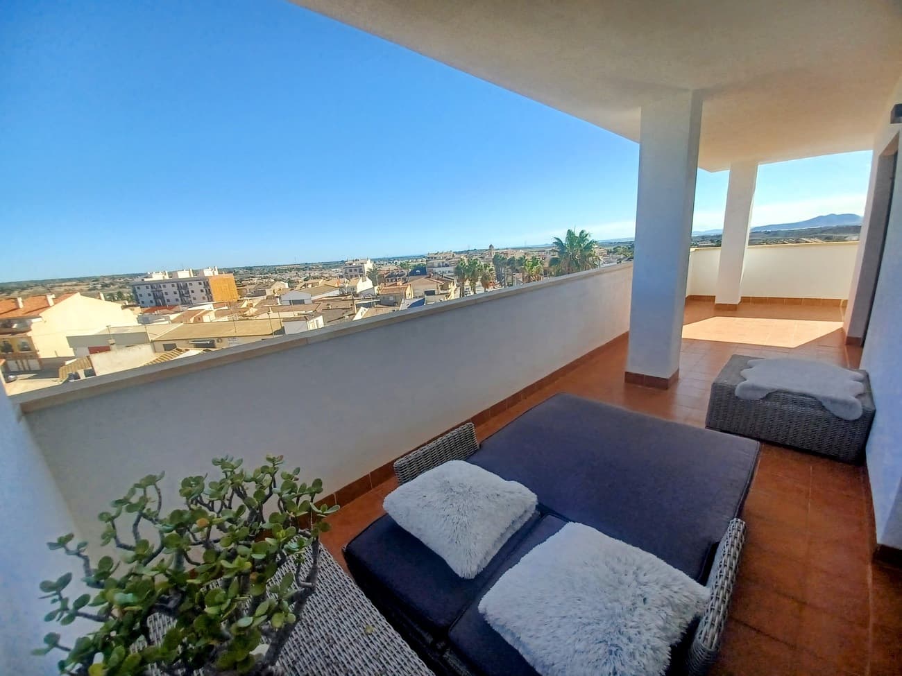 This unique apartment offers spacious living, large wrap around covered terrace with panoramic views across the traditional village of Sucina, the countryside and the sea.  The apartment enters into a hallway leading to a spacious living room with open plan kitchen to the left.  The living/dining room has plenty of natural light, it is  tastefully furnished with leather sofas, dining table and chairs, tasteful units, light fittings and ceiling fans with patio doors leading to the terrace to enjoy the stunning views.  The kitchen is fully fitted with granite worktop, ceramic hob, oven, extractor, fridge freezer and washing machine and a granite bar with stools leading to the living/dining area.  The living room leads to the right to the first double bedroom; it is a double bedroom with double bed, bedside tables and fitted wardrobes.  To the left in the living room is a bathroom with shower, wc and wash basin; tiled from floor to ceiling with quality white and neutral tones.  The second bedroom is the the left, a double bedroom with patio doors and direct access to the terrace to enjoy the morning sun this bedroom comes with bed, bedside table and fitted wardrobes.  The third bedroom is the master bedroom with en suite bathroom; this bedroom is large with double bed, bedside tables, ceiling fan, patio doors to lead to the terrace to enjoy sunshine all day long.  The en suite bathroom comes with a bath/shower, double sink vanity unit, spotlight mirror, wc and bidet tiled from floor to ceiling in neutral ceramics. The terrace is stunning, it is a large L shaped terrace with different areas, ideal to find sunshine or shade and can offer dining and lounge areas with quality wicker sofa, armchairs, 2 matching wicker sunbeds and 2 hanging string chairs to relax and enjoy the stunning views.  Set in the La Vereda building in an elevated position at the top of the village the building comes with granite floors in the entrance hall,  lift, communal pool and communal terraces.  Situated in the traditional village of Sucina with supermarkets, restaurants, bars, medical centre and pharmacy nearby it is an ideal place for all the family.  Sucina has live music at the church square every weekend all summer long to enjoy yet this building is a 5 minute walk to the main Square and it is in a quiet position.  Sucina offers a great quality of life and community; just 20 minutes drive to the coast with great beaches, 25 minutes drive to the city of Murcia and 20 minutes drive to the airport.  This apartment comes fully furnished as seen and is highly recommended for viewing.