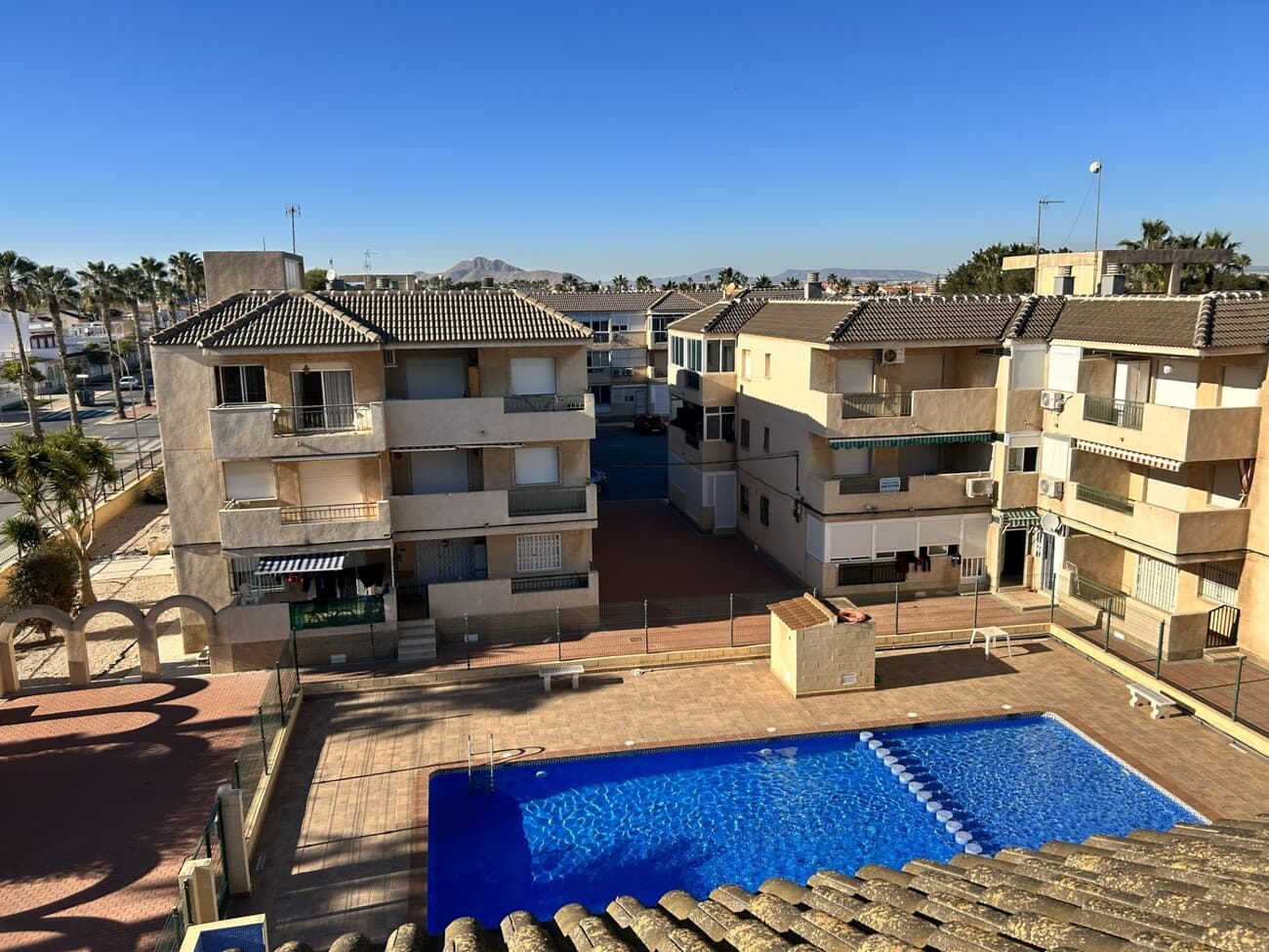 RESERVEDThis well-presented three-bedroom apartment is ideally located in Los Alcázares, just a 12-minute walk from the Mar Menor beach and within close proximity to a wide range of amenities, including restaurants, cafés, a pharmacy, a gym, and a local semi-private school. The weekly street market and nearest supermarket are only a 5-minute walk away, making this an exceptionally convenient location.The property offers 65 m² of living space and features three bedrooms (one double and two single rooms), a family bathroom, and a large balcony, perfect for outdoor dining or relaxing. Comfort is ensured year-round with new air conditioning and heating, complemented by ceiling fans in every room. The apartment also benefits from windows fitted with safety shutters and mosquito screens.Residents enjoy access to a large communal swimming pool surrounded by landscaped gardens, as well as a spacious community terrace. The building is a quiet and well-maintained block, home to a mix of international and Spanish residents.This apartment is an ideal lock-up-and-leave property, offering secure parking within a gated community. Located on the first floor, it has an external private front door and an additional security gate. Gates at the rear of the community provide direct access to a nearby park.Excellent transport links include easy access to the motorway, major bus routes to nearby cities, and an airport shuttle bus stop at the end of the road.A fantastic opportunity for permanent living, a holiday home, or a rental investment in a highly sought-after area.