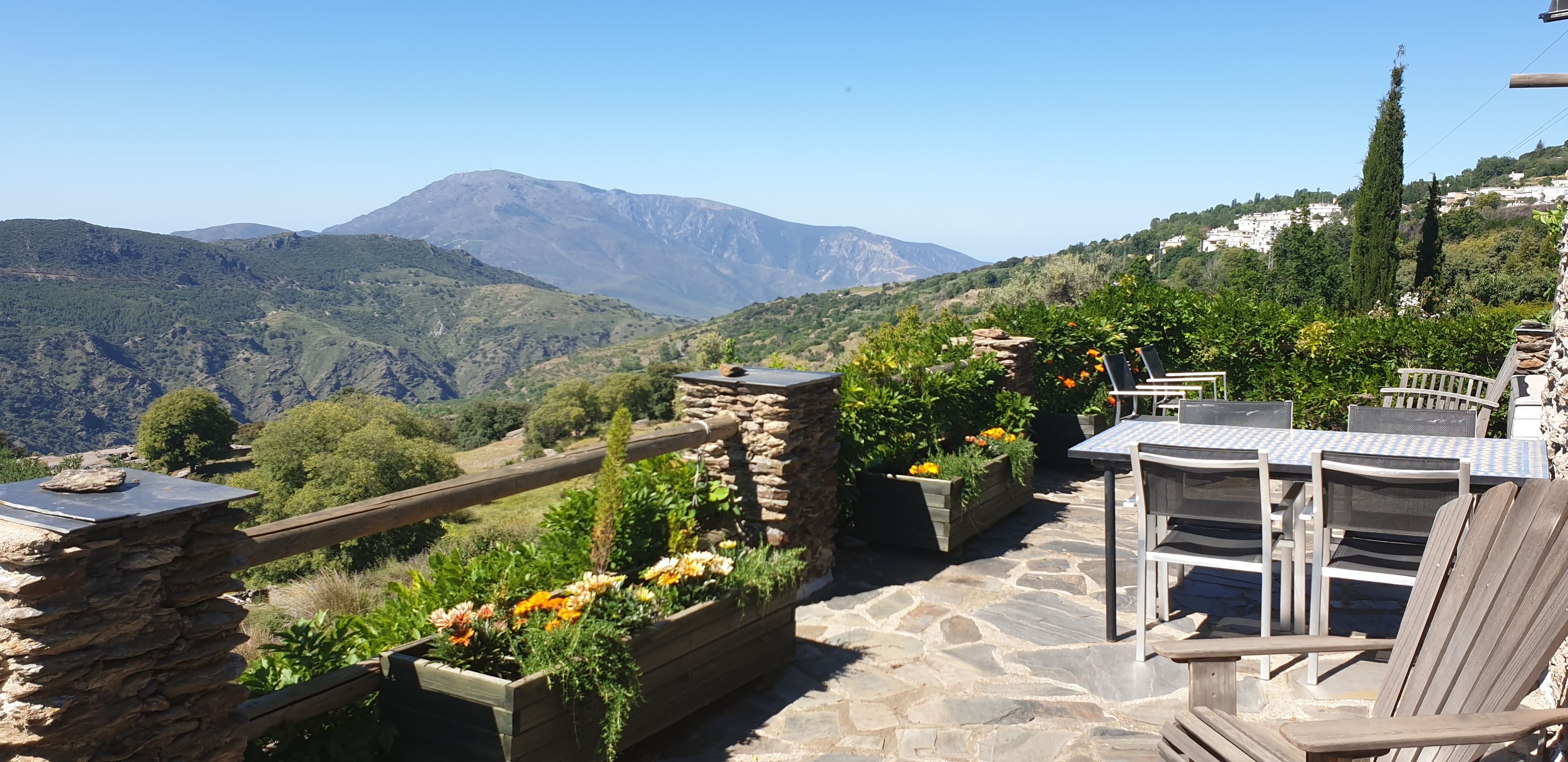 Large villa with spectacular views in Alpujarra Natural Park, GranadaTraditional stone Cortijo divided into two floors with three apartments, can easily be converted into a large family residence if desired. Located in the Alpujarras Natural Park in Granada, with a short walk to nearby villages and surrounded by space, beauty, tranquility and spectacular views.The property is currently run as a successful rural tourism business (licensed by the Granada Tourist Board) and provides sufficient income for the couple living there. Whoever buys the property will have income from the business from day one, the property is sold with the company's goodwill, including websites, email lists etc.The property has been renovated to a high standard, including central heating and underfloor heating powered by an energy efficient heat pump. A new roof was added in 2019 with extra insulation for winter and summer comfort. The property is distributed as follows; Ground floor - Two one-bedroom apartments with double bed, used for rental. Each apartment has a living/dining room, kitchen, bathroom and patio.Top floor, where the owners live. Two-bed apartment, kitchen, two bathrooms, large living room with dining area and floor-to-ceiling windows onto the terrace, providing plenty of light and a wonderful view. In addition to the property there is a separate building/cortijo which is attractively built and finished in stone and used as storage, garage and workshop. It measures 55 metres square and has electricity, drinking water and its own drainage system. There is a kitchen and an outdoor kitchen with a large wood stove, could easily be converted into a building for alternative use such as rentals.All housed in a large garden with fruit and olive trees. There are two water reservoirs, one of which can easily be converted into a swimming pool if new owners wish. Solar panels and heat exchangers, for an environmentally friendly and cost-effective electricity consumption. In summary, an exceptional property that is difficult to describe in words. It simply must be seen, sold partly furnished.
