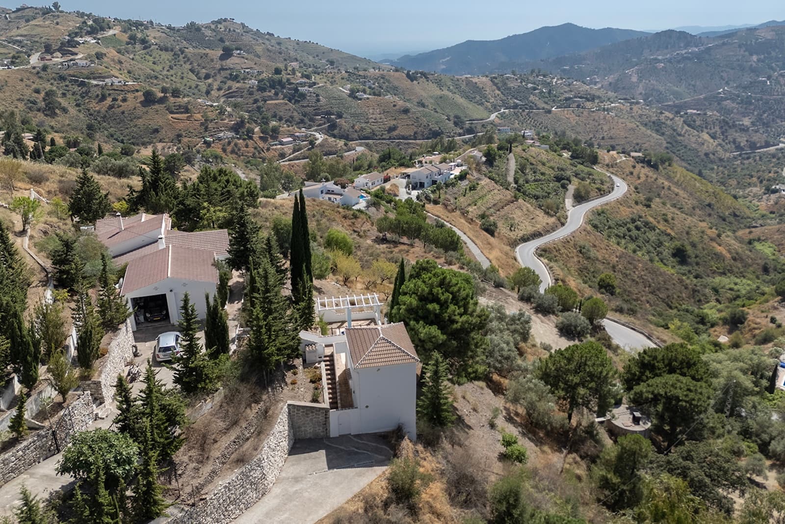 Charming Luxury Country Property with Guest House, Garage and Pool -Close to CompetaJust above the main road, near the charming white village of Cómpeta, you’ll find this peaceful oasis. The house is perfectly situated, offering privacy and tranquility, while still being within walking distance of the lively village center. Here, you can enjoy the cultural life, the warm atmosphere, and a wide selection of excellent restaurants.From the matured garden, you’ll be treated to spectacular panoramic views of Cómpeta, the surrounding mountains, stunning sunsets, and even the Mediterranean Sea in the distance. The gated property is easily accessible by a short drive, with two well-maintained driveways providing access. Parking is available both outside and in a spacious garage that accommodates two cars and offers great storage room. You enter the home through a lovely sunroom, an inviting space with beautiful views and a cozy feel. From there, you step into a bright and spacious fully fitted kitchen with a dining area and wood-burner stove. A hallway with build-in wardrobes leads to a guest room or office, along with a bathroom. The living room is generous in size and features a wood-burner stove, a small bodega, and a dining area, making it ideal for relaxing and entertaining. The large master bedroom includes a private ensuite bathroom with plenty of space.Outdoors, the property offers numerous terraces and garden spots to enjoy the peaceful surroundings and spectacular nature. One level below the main house is a separate guest house on two levels. The upper level has an open-plan kitchen and living room, while the lower level includes two bedrooms and one bathroom, with the swimming pool just outside.The entire property has been fully renovated, has double-glazed windows and central heating on gas and is in excellent condition. The property is sold furnished and ready to move in. It is perfectly suited as a permanent residence, a holiday retreat, a rental opportunity, or a long-term investment. This unique home and its surroundings must be seen to be fully appreciated.Please contact us for more information or to schedule a viewing.General information:5 min to the city by car – 25 min walking25 minutes to the coast45 minutes to Malaga60 min to Málaga airport90 min to Granada (Al Hambre)120 min to Sierra Nevada (skiing in winter)2 ½ hours to Gibraltar2 ½ hours to Cordoba3 hours to Seville.