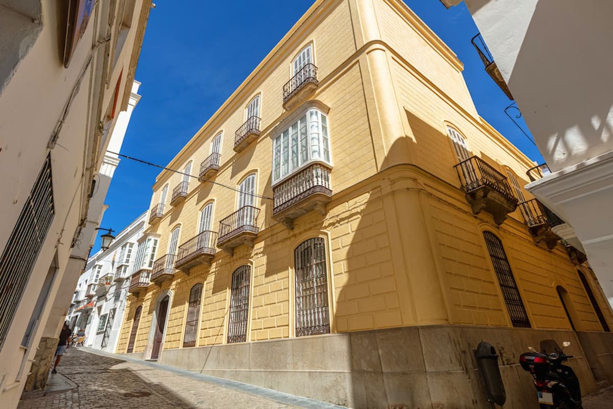 Welcome to a historic gem in the heart of Tarifa's old town! This majestic 19th century detached villa, built in 1850, offers a unique opportunity for visionary investors. With 1,081 m² built, this property is distributed over three floors and has 20 bedrooms and 4 bathrooms, making it ideal for both residential use and a tourist-commercial project.The main floor welcomes you with an elegant entrance hall, several lounges, storage rooms and areas that can be transformed according to your needs. The first floor houses a spacious living room, dining room, office, kitchen and bedrooms, as well as a charming interior courtyard that illuminates the space with natural light. The upper floor has bathrooms, double bedrooms, toilets, a laundry area and an impressive terrace with panoramic views of the old town and the port.The property stands out for its luxurious qualities for its original period, with marble and hydraulic tile floors, high ceilings and architectural details such as tiles and period ironwork. In addition, it has a large central courtyard with galleries and other smaller courtyards that bring light and ventilation to the interior of the building.The south and east orientation guarantees excellent natural light throughout the day. Although the property does not have heating, its structure and design allow for a pleasant temperature all year round.Don't miss the opportunity to acquire this unique piece of Tarifa's history. Contact us for more information and to arrange a viewing, your dream of living or investing in a property with character and potential is just a step away from becoming a reality!