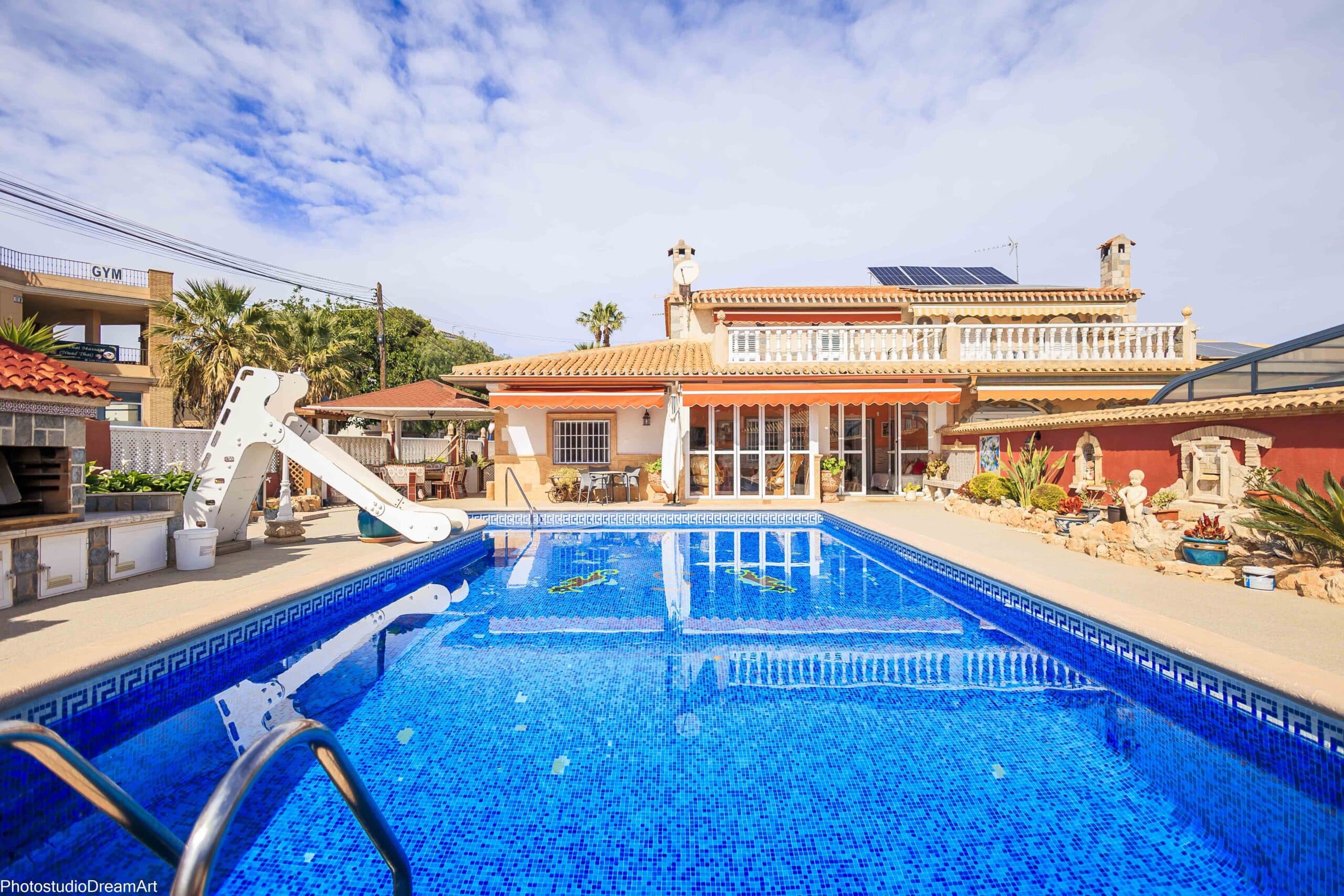 Semi-detached villa for sale with swimming pool and garage near the beach of Cabo Roig.The villa stands on a plot of 510m2 and has a fantastic outdoor area: garage for 2 cars, a swimming pool with slide, outdoor kitchen with barbecue, a veranda, sun and seating areas, storage space, etc…The villa has 5 bedrooms, 2 bathrooms, a guest toilet, a separate fitted kitchen with dining area and a door to the outside and a livingroom with fireplace. A/C and ceiling fans.The beautiful beach of Cabo Roig is only 1,3km, 3km to the golf course and 1,5km to the popular shopping center La Zenia Boulevard. All possible amenities nearby.