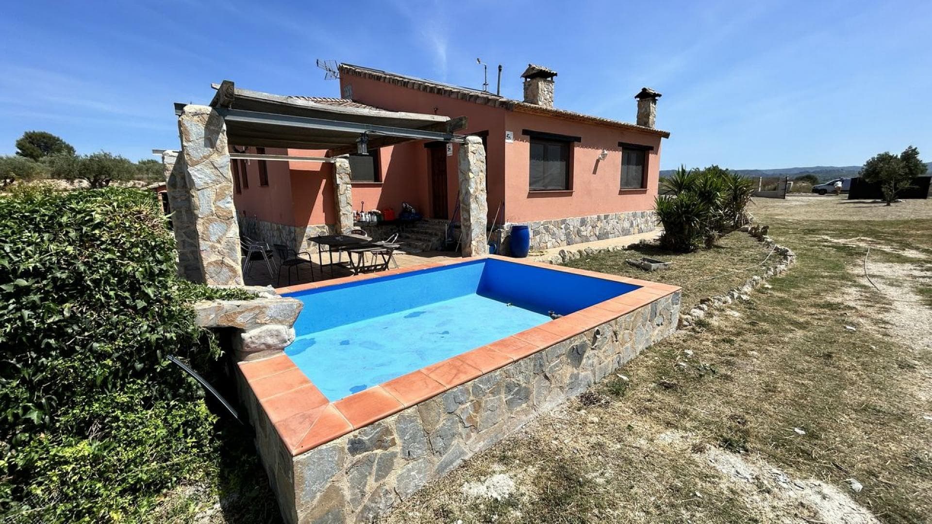 Country Chalet (280m2) with an adjacent Commercial Warehouse (160m2) built on a 12,957m2 (15,54 fanegadas) of land in the municipality of Benigánim!This Chalet build has been approved and registered by the local town planning authority. It is situated in a quiet area of natural beauty on the outskirts of Benigánim. Centrally located in a grassy fenced off plot of 6,765m² planted with centenary Olive trees and served by paved roads to a rolling steel gate.  Just a 5-minute convenient drive to reach town centre and a just short 35-minute car journey to enjoy the beautiful sandy beaches of the popular nearby holiday resorts of either Oliva and Gandia. This property is surrounded by open un-spoilt countryside yet just 20 minutes’ walk takes you to the local railway station which is connected to the whole of Spain. The Bellús lake is nearby making it an ideal trail for horse riding or just walking the dog, accessed directly from the front gate without busy roads to cross. Fully legalized and documented, the Chalet was built in 2007 using top quality thermal materials, combining a Mallorca influence with rustic elements.Ideally located, Benigánim is a municipality in the comarca of Vall d'Albaida in the Valencian Community, situated between the villages of Quatretonda and La Pobla del Duc. It consists of approximately 6,000 inhabitants, it has a medical center and good shopping facilities, including 3 major name supermarkets and a once-a-week eco fruit and vegetable market held on the town square.Benigánim was a historic Medieval town of worship in the Borgia dynasty and is located to the south of the province, 80 kms. from Valencia. It is well placed, just 45 minutes from Valencia Airport and just over an hour from Alicante Airport linked by easy nearby motorway access. The town has a railway station and is a short commute to the main railway hub in the nearby City of Xátiva which in turn, is joined to the main-line network serving both Valencia to Madrid. The valley plot has a climate with mild temperatures throughout the year, the valley is internationally renowned for growing soft fruits, perfect to enjoy its many cultural activities, its acclaimed festivals, its beautiful historic town center and its warm people.This very spacious family home is distributed on one floor, its 200m2 floor space is divided into well-proportioned rooms and is warm in Winter and naturally cool in Summer due to its large volume and layout.  An outstanding feature is the large living-room with its high vaulted Mallorca beamed ceiling creating a relaxed feeling of space and here the terracotta tiled floor has been randomly decorated with multi-coloured hand-made biscuit tiles. Imported from Austria, this large cast iron wood burning stove has been set-in a high stonework chimney acting as a focal point. (Provision has been made to install a wooden mezzanine floor with staircase should you require more space). This lounge is connected to a large bright dining room that enjoys 180º panoramic mountain views to the nearby National Park and is ideal room for entertaining guests with yet another log burner chimney as a corner feature, again set-in similar natural stone.From the lounge there is a large adjoining kitchen, linked through an open arch made from stone found locally. This room has a decorative Mallorca arched-brick beamed ceiling with an L-Shaped work surface that has been cut from one large slab of exclusive dark Italian marble. There is an island storage unit to prepare food or simply enjoy a communal breakfast sat on stools; Service connections exist for both a washing machine and dishwasher together with a double-sink in front of a window, supplied with hot water from a wall mounted butane boiler which also serves a built-in gas range cooker.The master bedroom also has a log burning stove with a chimney set-in natural stone. A nice free-standing carpentered double wardrobe made from Walnut is included. The other bedrooms and bathrooms are connected via a long airy hallway and accessed through natural wood doors. The passageway is recessed with a built-in chimney, ready for a pellet burner and there is access via a manhole to the basement. The entire Chalet has exterior pine cased windows and doors, glazed with 7mm “anti-theft” laminated glass and supported by railway sleeper beams. Thermal insulated bricks were used throughout including the partition walls, meaning the inside remains cool under the hot summer sun with no real need for air conditioning and the same build provides good insulation during the few colder Winter months.There is a large bathroom which is equipped with an Italian designed jacuzzi jet bath with hot water connected to another wall mounted gas boiler. The second bathroom has a walk-in decorative stone shower and hot water is supplied from the same independent butane boiler. Drainage for the building is to a distant self-emptying eco-friendly septic tank. A tall metal mast has been installed for a wind turbine. The property is connected to the town mains water and has eco-friendly energy from roof mounted photovoltaic panels; So, no energy bills to pay!The property offers an additional 80m2 under-build, with a tiled floor. The basement is home to the solar panel inverter and batteries and is easily accessible by an up and over 3m wide garage door. The space is perfect for conversion to a cool sub-terranean office, workshop, gymnasium or left simply as garage parking space for 2 cars.A concrete tiled footpath provides easy maintenance to drains and follows the building round to the large garden, which is mainly laid to cut grass and includes a gravel car park and drive to the entrance closed off by a heavy metal gate on rollers. The back door from the dining room leads down a few steps to a shady tiled patio with an adjacent flood-lit pond and cascade, ideal for a barbeque. A separate single phase electrical connection exists with an adjacent tiled space for the buyer to install a large 6 person Jacuzzi in the future at no extra costs. From this area, you can enjoy panoramic views from east to west. The distant mountains and the surrounding agricultural landscape are a wonderful location and altogether invites one to relax and enjoy the purely Mediterranean environment. The un-polluted dark night skies provide the ultimate star gazing entertainment for this idyllic family residence!There is an adjacent 160m2 commercial warehouse, included in the asking price!This structure has been approved and authorised by the local town planning authority. The warehouse comprises of a 160m2 welded metal, high steel frame with solid brick-built walls and metal framed windows protected by security bars; The roof is of convoluted metal-foam sandwich panels which lower the thermal temperature in Summer and are insulated to retain heat loss in the Winter, included are 4 clear plastic roof panels that provide ample daylight. The structure is connected to the town mains water and has eco-friendly energy from roof mounted photovoltaic panels; This warehouse can provide the buyer with an ideal opportunity for starting up an economic business model from home!The front entrance is secured by a double steel door and with a loading bay that provides good access for small lorries. The entrance at the rear is fitted with a high security metal door.  Ample metallic storage shelving increases the available floor space.  2 suspended industrial fluorescent tube light fittings, TV aerial and a chimney for a wood burning stove are included. The building has a built-in cabin with a toilet, wash-hand basin and a hot walk-in shower connected to a wall mounted butane gas boiler. Drainage is to a nearby eco-septic tank. There is a shady concrete patio to the rear with an outside tap. As an alternative to a business venture, the building can be converted into a legal 3-bedroom detached house at very low cost!The high-spec warehouse has great potential for various commercial enterprises and is located just 15 minutes distant from the national motorway network; For example, Online commerce storage and distribution or say a dog, cat and horse holiday hotel. The warehouse lends itself particularly to convert into a stable for horses with the equestrian centre enjoying miles of open country trekking and riverside trots on the doorstep with literally no roads to cross. Especially as the building stands on a 1,581m2 fenced plot and has already been licensed for horses. There is also a secure chain-link fenced-off chicken run incorporated to the side of the warehouse accessed for maintenance by steel gates. The grazing land opposite the warehouse also has permission to be fenced off.  At the moment it is a 4,611m2 triple-terraced open pasture enjoying a plumbed water supply. A detached house with amazing views could be built on this plot subject to planning permission approval!An adjoining 4,611m2 plot of good agricultural “grazing” land will be INCLUDED in the sale!