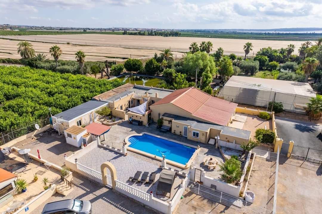 DREAM HOME in beautiful Los Montesinos, Alicante, Spain! This unique Finca/Villa is a fantastic opportunity to invest in your dream home with countless possibilities! The home is 382m2 and its facilities appear well-maintained and modern with traditional Spanish charm. In Los Montesinos you can fully enjoy the Spanish environment and tranquility while still being close to all facilities and services. This finca/villa is perfect for those who want to run, for example, a Bed & Breakfast or a campsite that has been established. There are 2 pools, one of which is currently used by the current owner and the other as a pool area for a possible b&b or camping, with really beautiful areas for lots of social gatherings and barbecues. Here you get a really good investment with the option of renting campsites and bed and breakfast! In the private villa you will find 3 bedrooms and 4 bathrooms with access to the 6x11 meter private pool. In the rental part you will find a closed pool and a total of 40 beds, 12 toilets and 7 bathrooms. The plot of 7700m2 contains a lush garden with beautiful trees, plants and outdoor seating, all of which offer a beautiful and tranquil oasis with views over the surrounding area. 6 caravans (of which 2 are long-term rentals) of 30m2 each In addition, this fantastic home and plot offers: A bar of 40m2 to gather family and guests for festive gatherings on the many beautiful sunny days and evenings. Great advantages of this property; Free electricity as there is a solar system on the roof - can generate 5.5 kw per hour. So privately, you will have free consumption of electricity - at the same time, you will be able to bill each user electronically in each caravan in terms of rental. Rental caravans; currently established with 2 long-term leases for 700 euros + electricity per month. 4 caravans with 97 euros + electricity per day. Large parking for several vehicles. Partly furnished Additional equipment: Air conditioning, central heating and many other facilities. Orientation: South facing Los Montesinos is close to fantastic beaches, golf courses, restaurants, shops. Distances : 2 km into Los Montesinos 14 km to Torrevieja 4 km to the motorway 54 km to Alicante airport Tender price €900,000 ex VAT Welcome to finally contact us for more information and a private showing